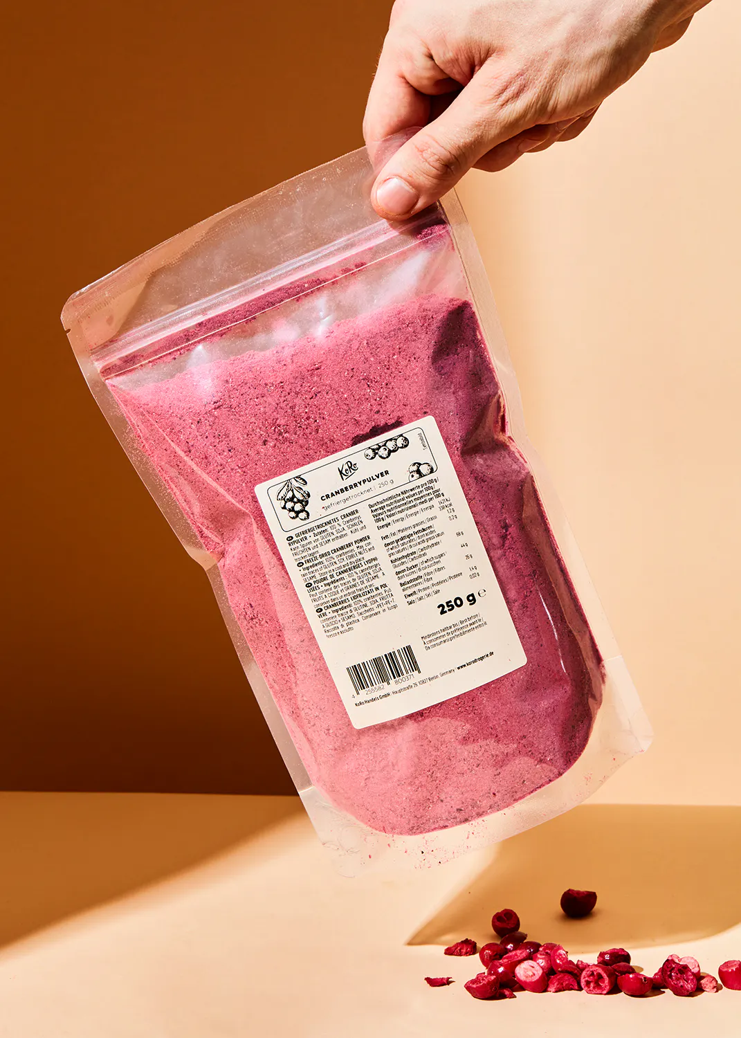 une personne tient un sac de poudre de cranberry