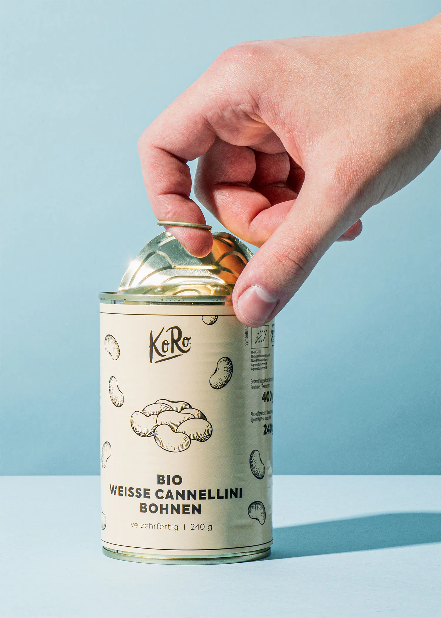 une personne ouvre une boîte de cannellini bio
