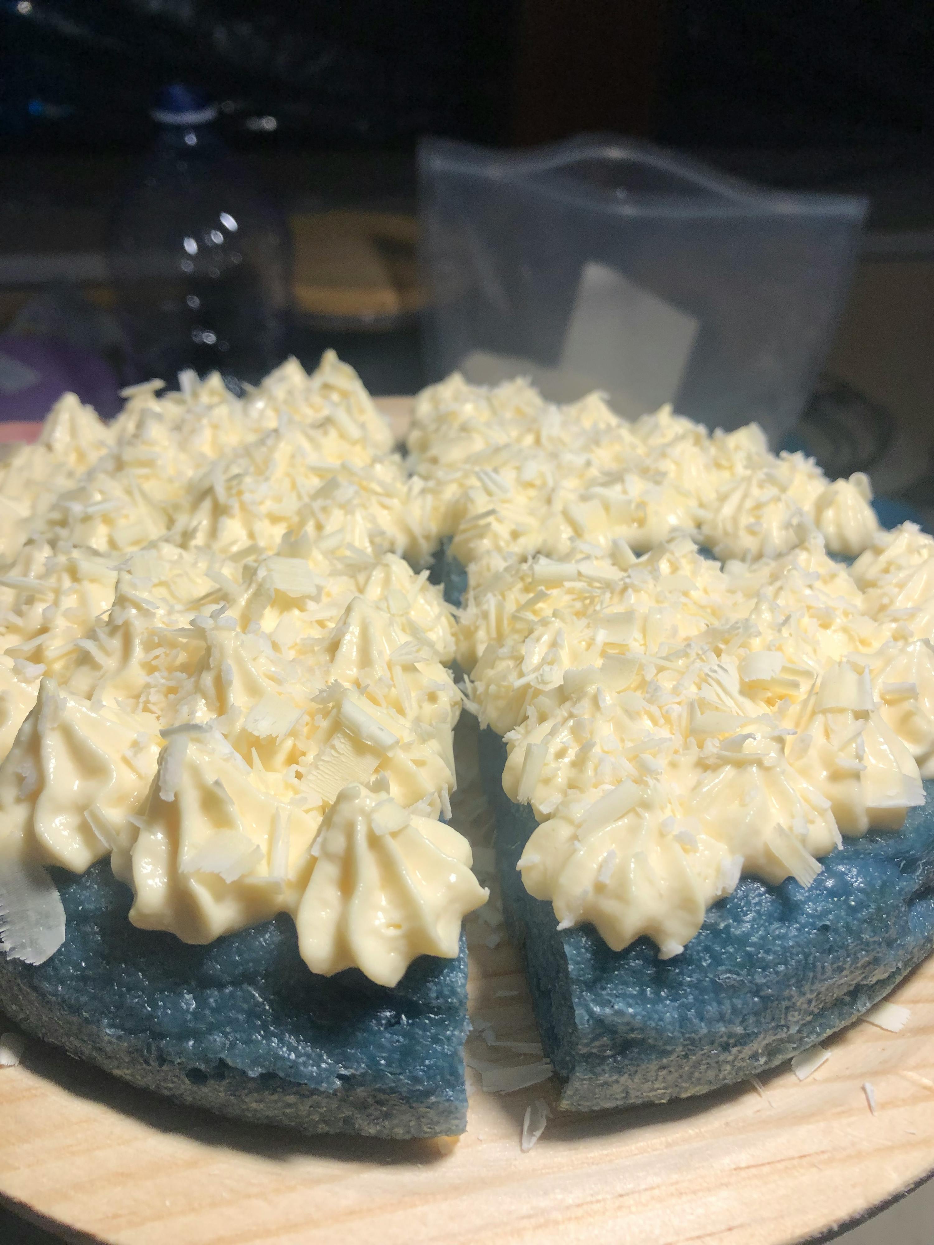 una torta blu con crema bianca e granella di cocco
