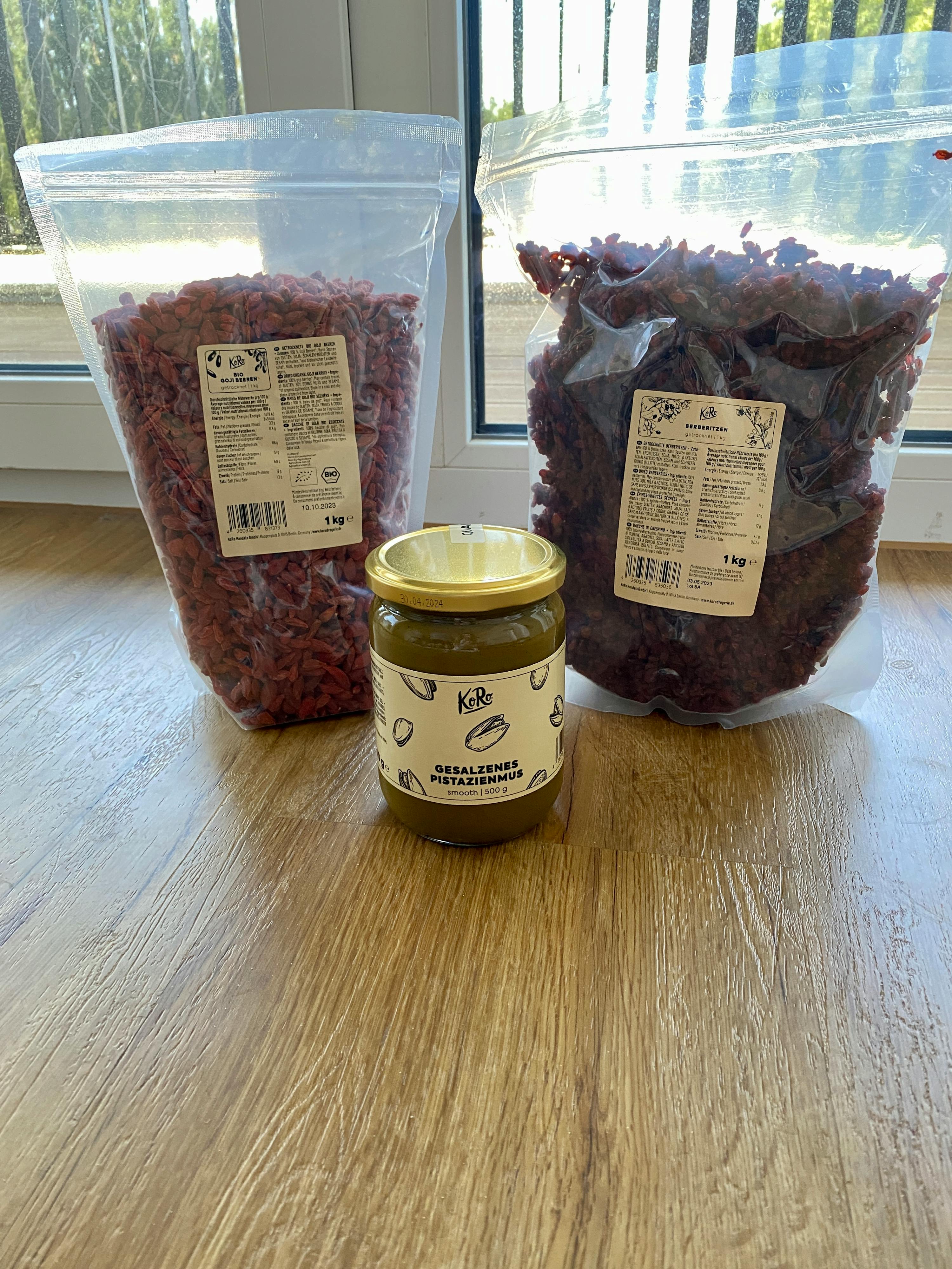 un barattolo di marmellata è seduto su un tavolo di legno accanto a un mucchio di cereali