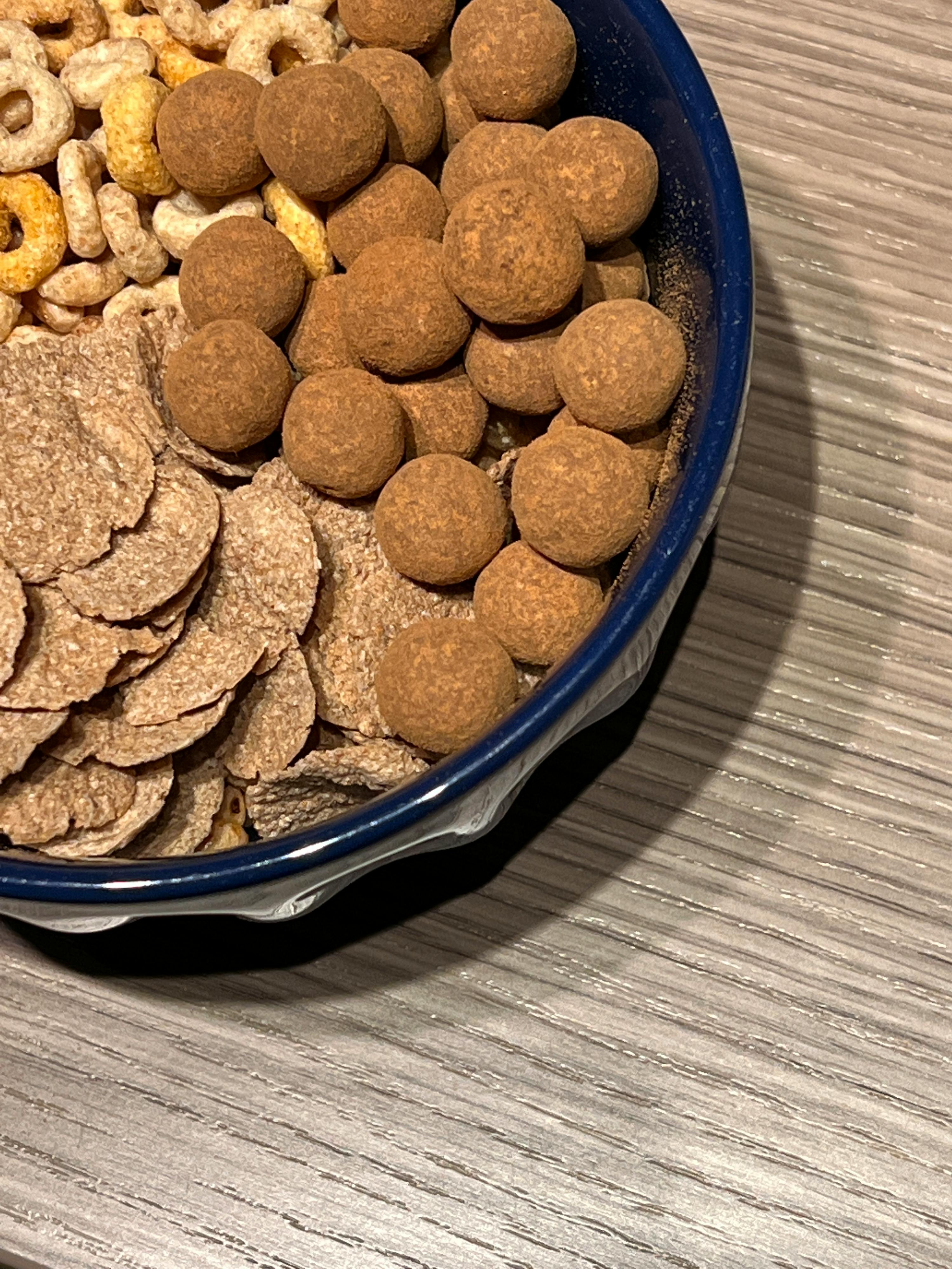 eine blaue Schüssel voller Müsli und Schokoladenkugeln