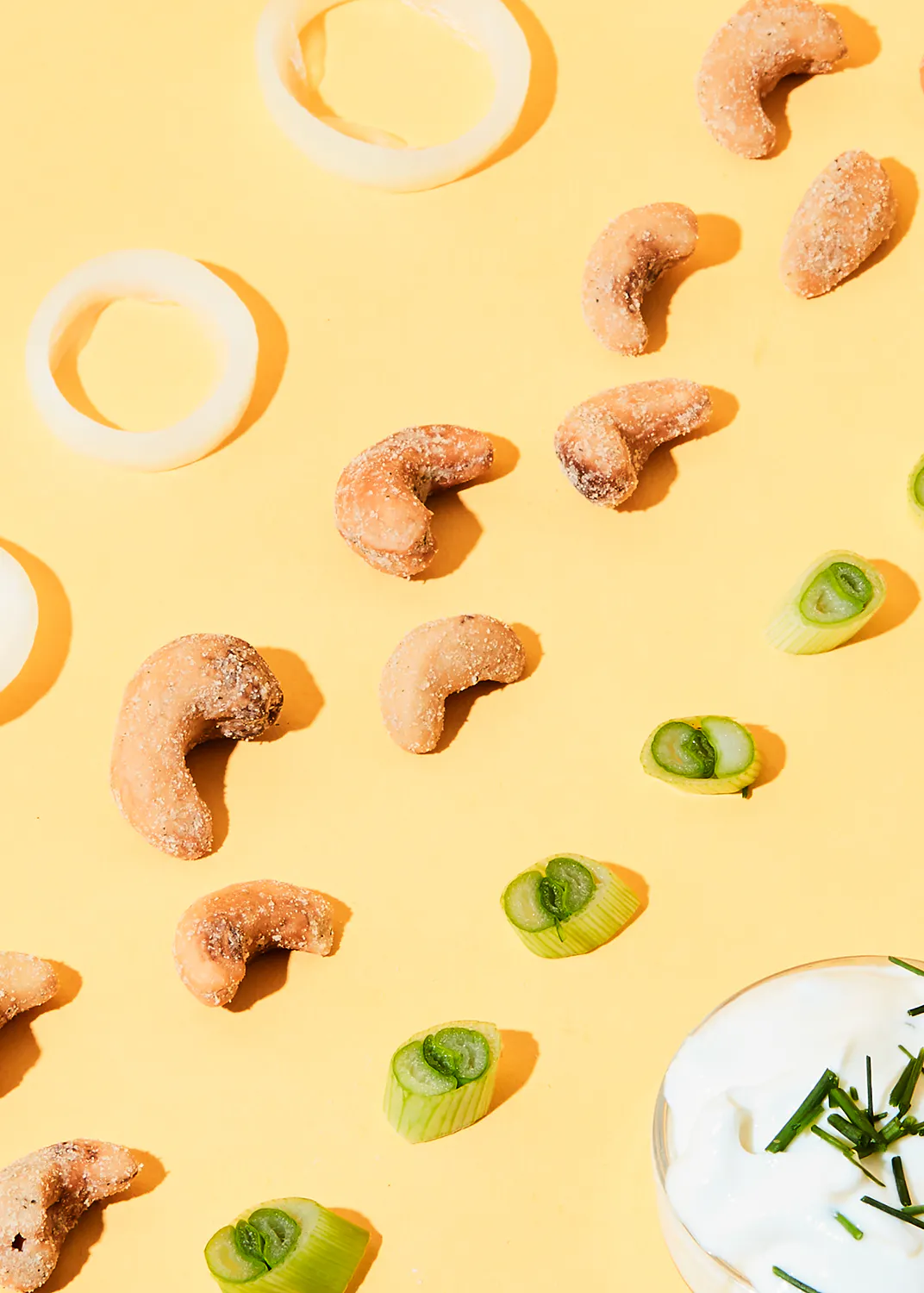 un tas de noix de cajou et de légumes sur un fond jaune