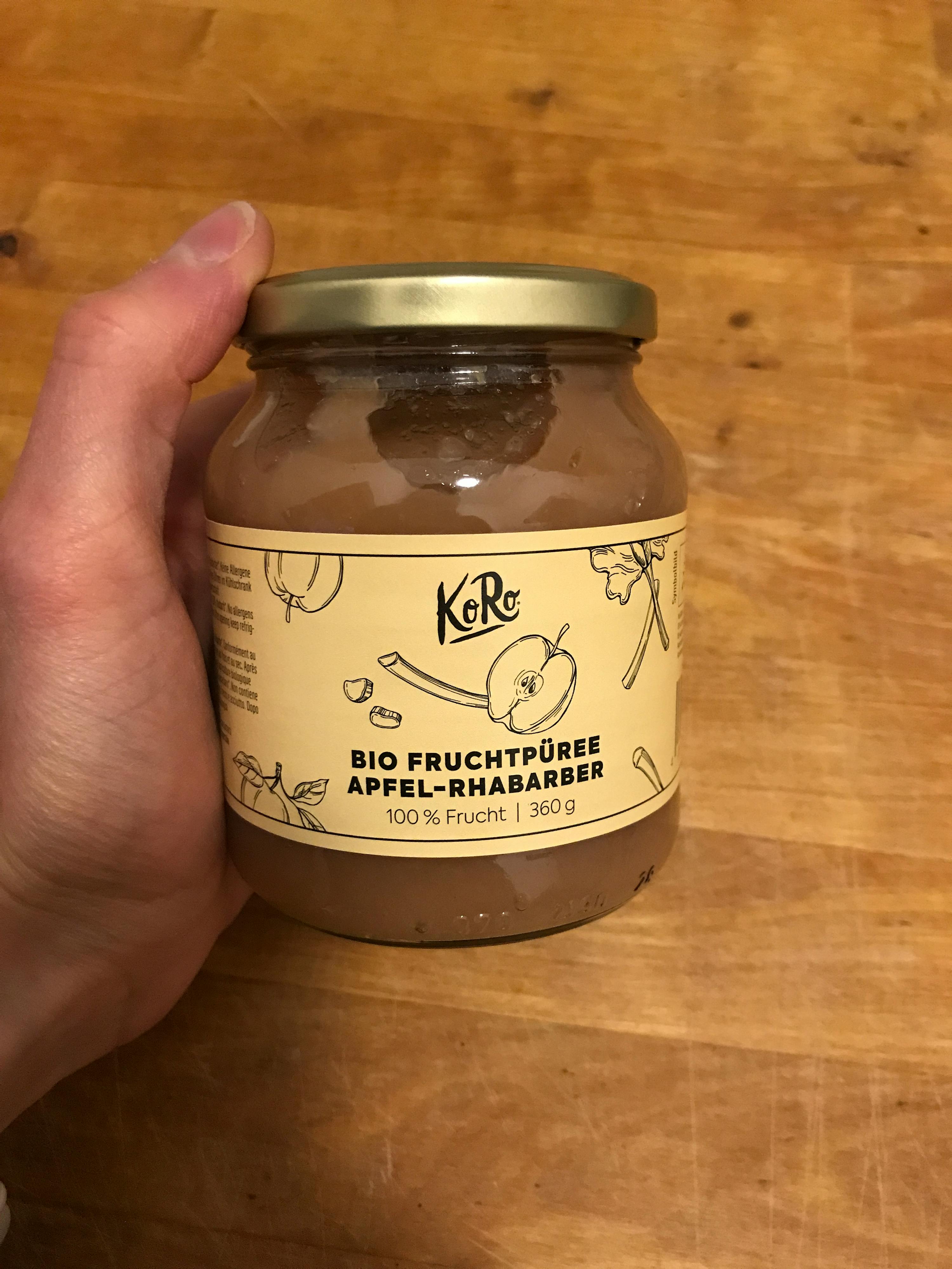 una persona tiene in mano un barattolo di marmelada di mele