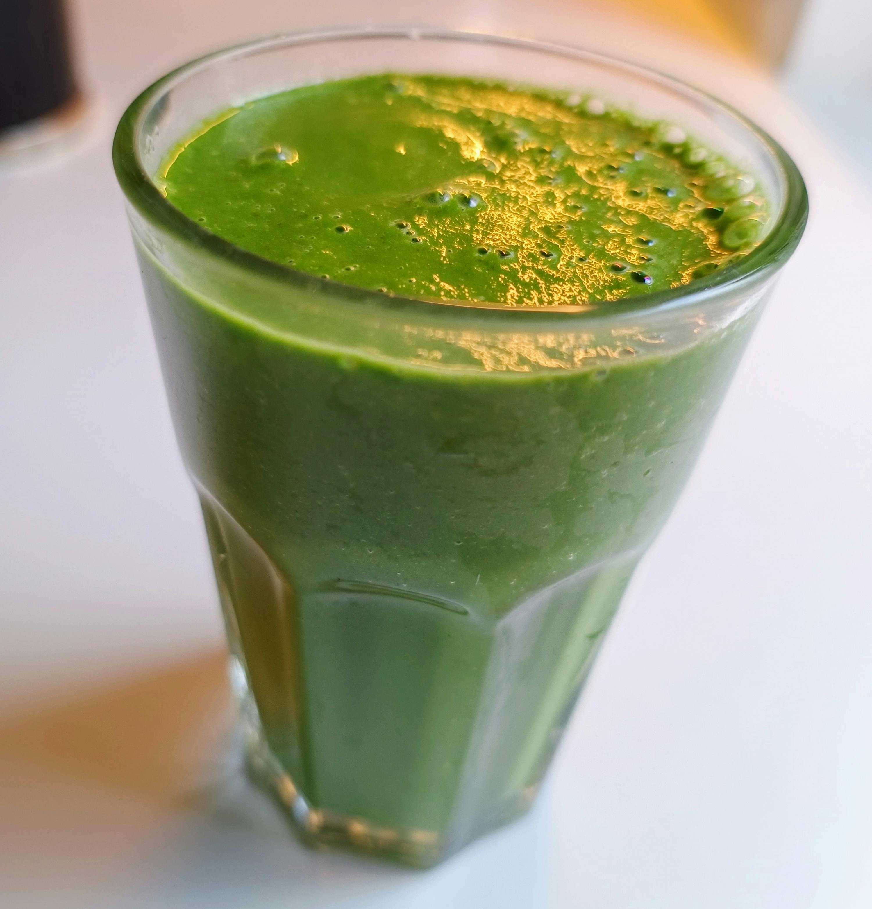 a green smoothie in a glass on a table