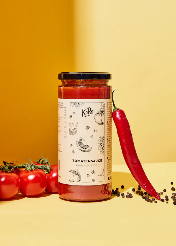 une bouteille de sauce tomate avec une étiquette blanche et un dessin de tomates