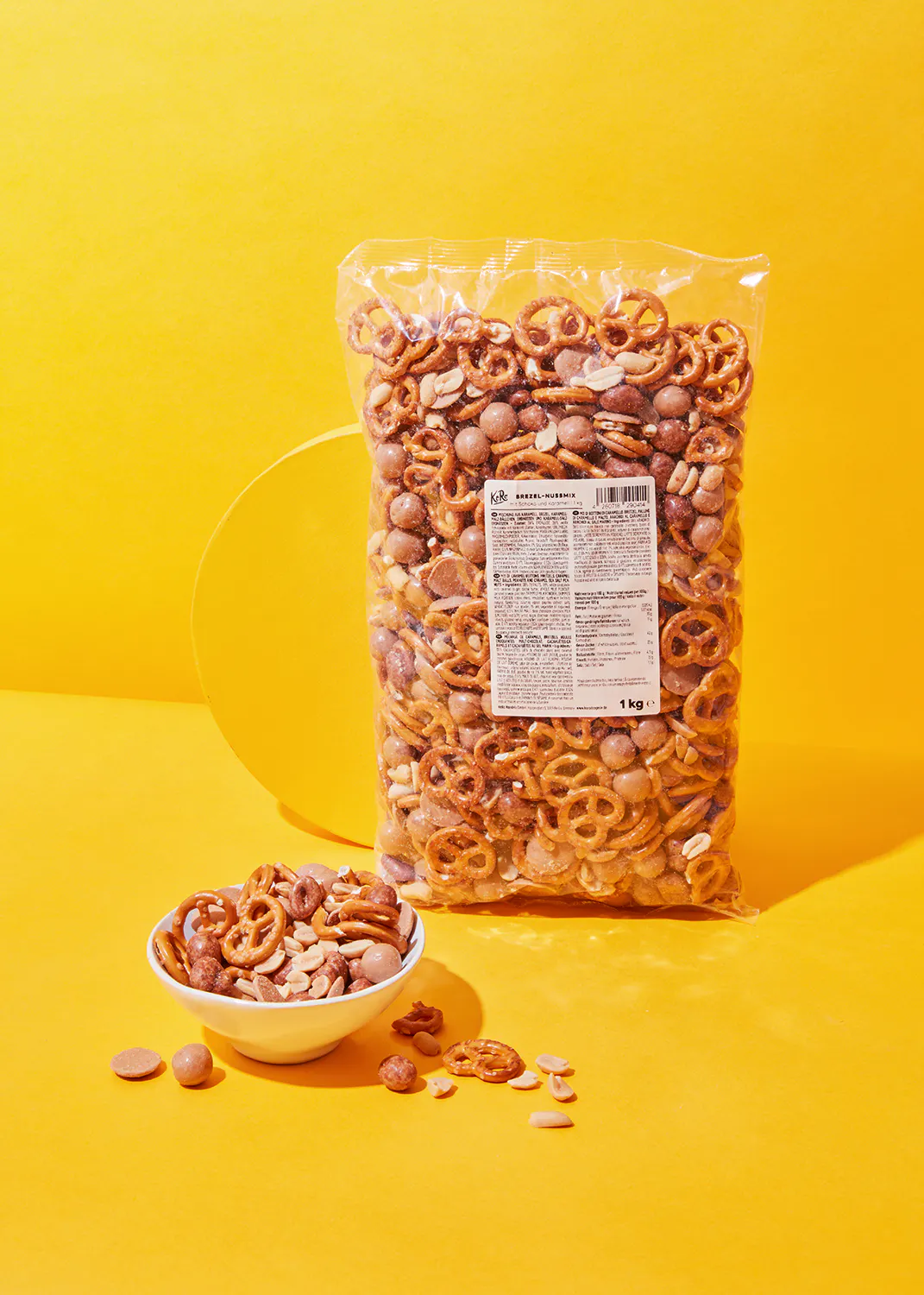 un sac de pretzels et de cacahuètes est assis à côté d' un bol de pretzels et de cacahuètes