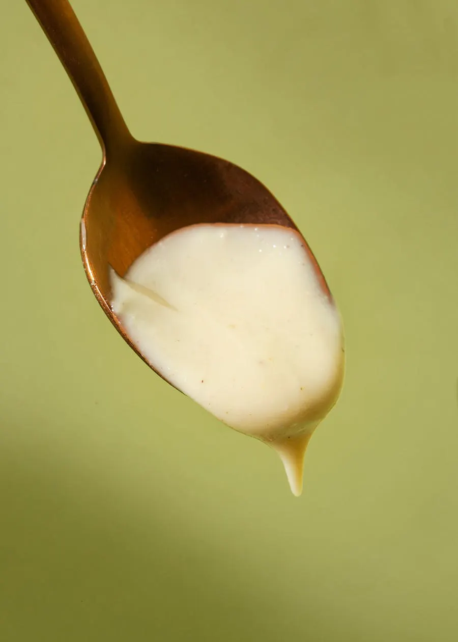 a wooden spoon is filled with a white liquid