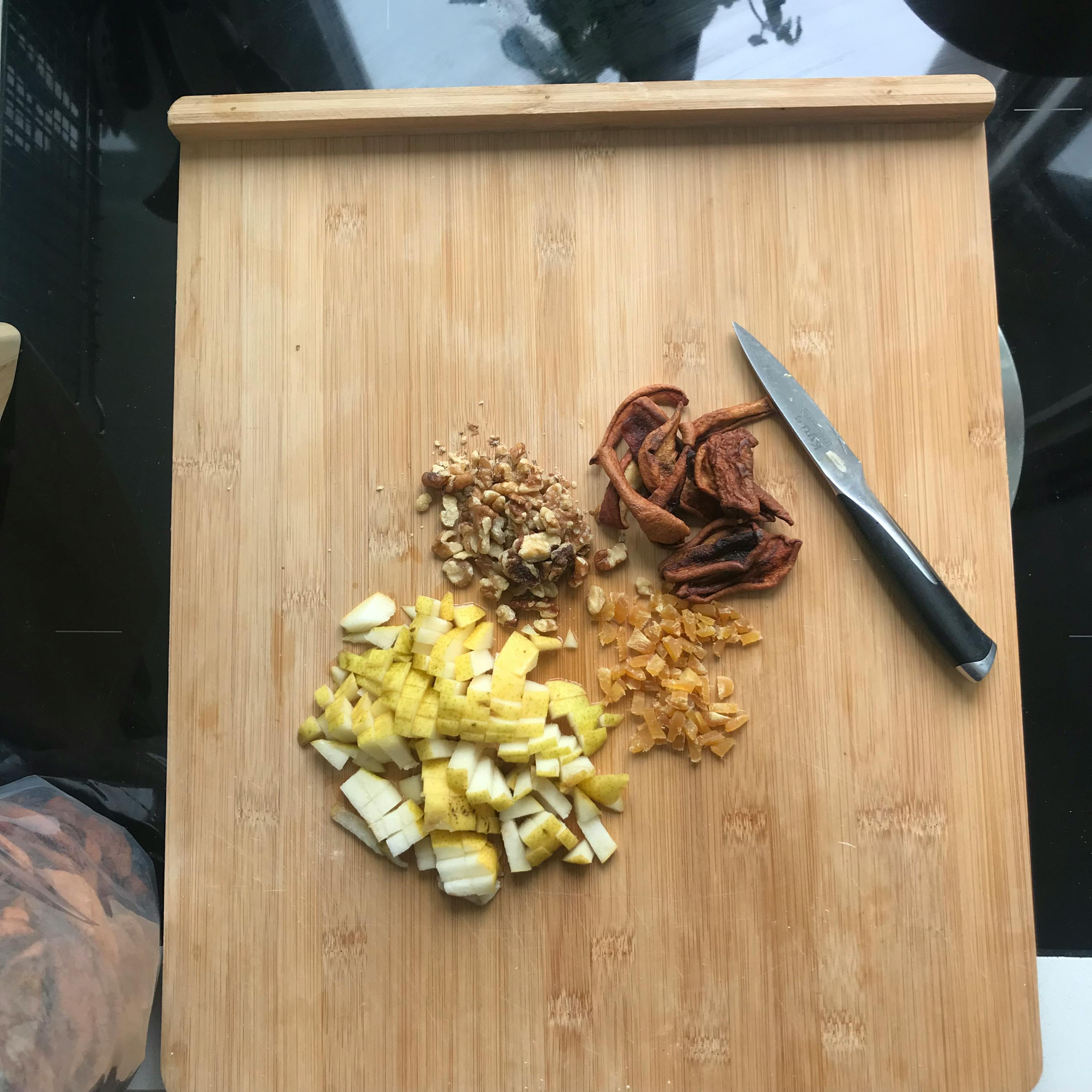 un tagliere di legno con diversi tipi di frutta e un coltello