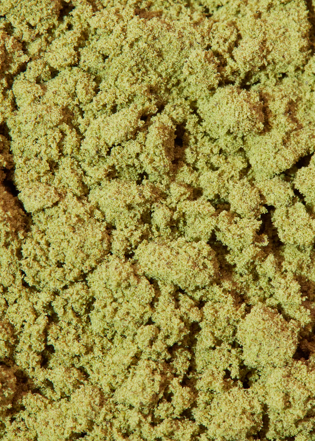 a close up of a pile of green and brown powder