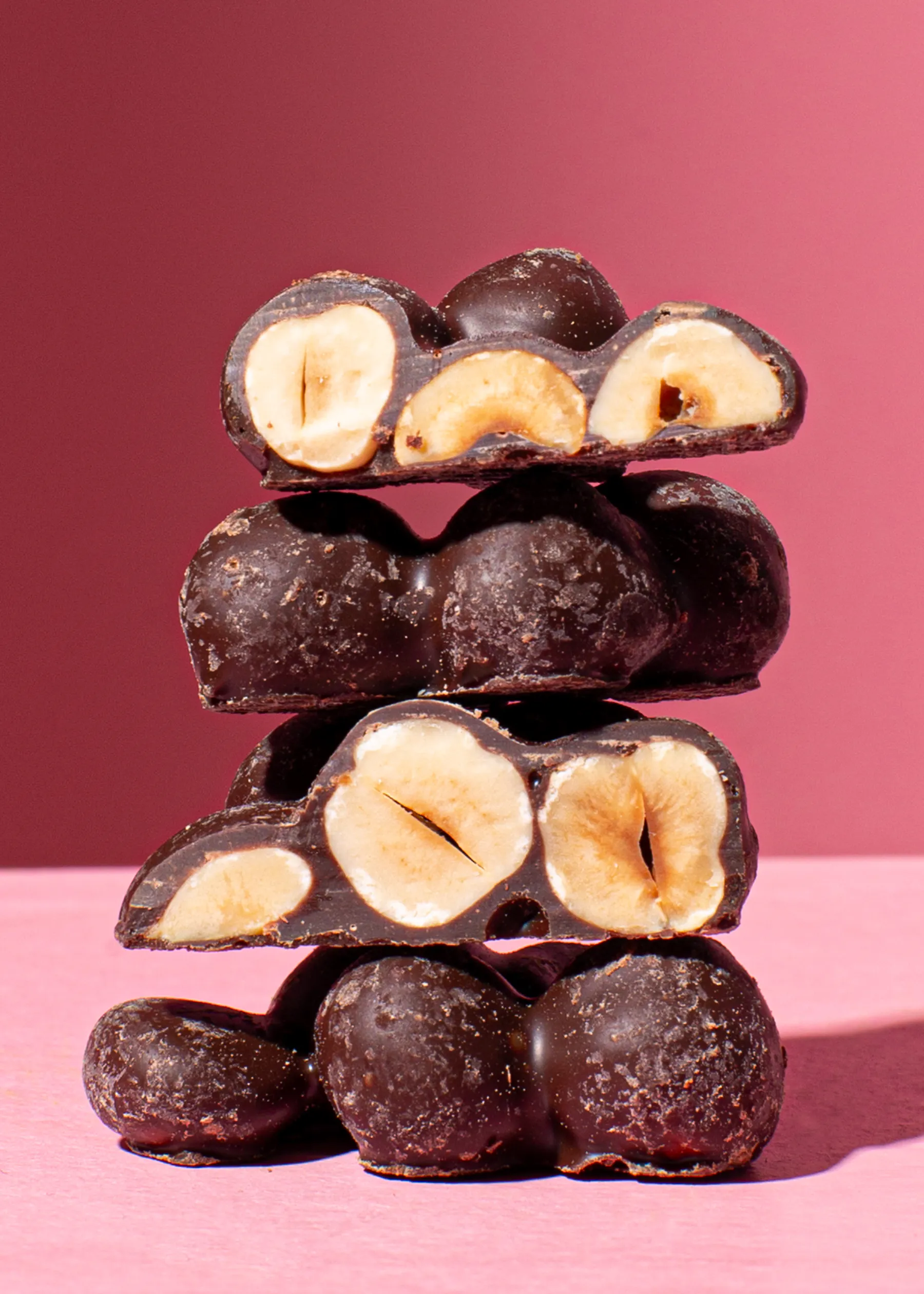 un tas de noisettes enrobées de chocolat noir empilées les unes sur les autres