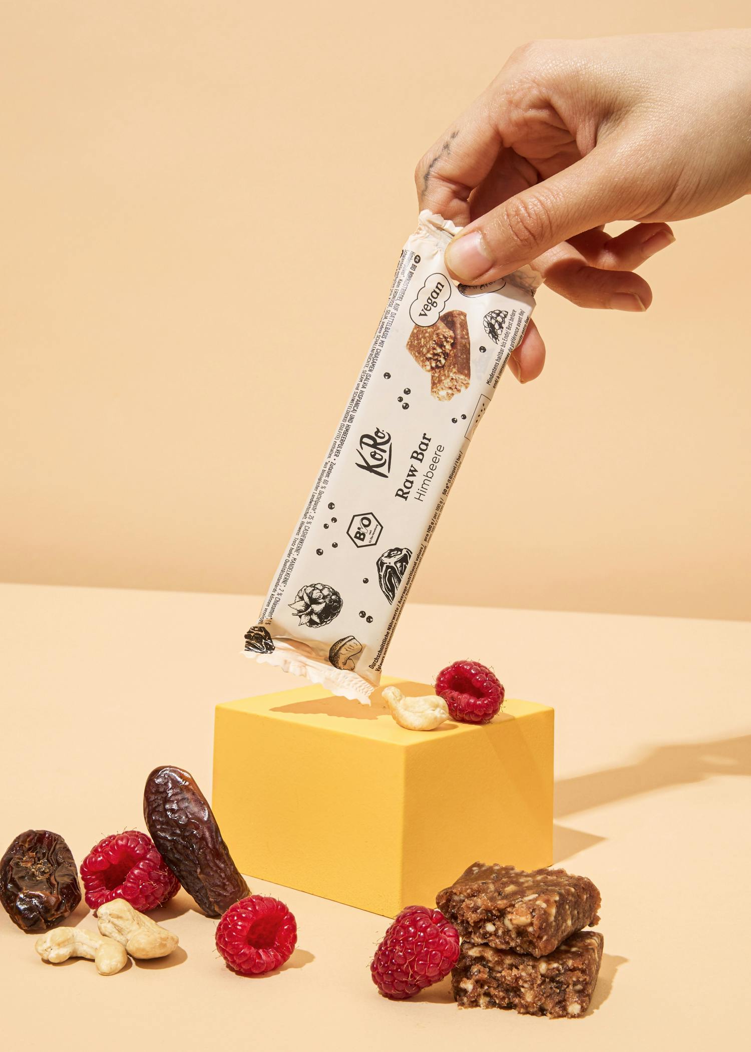 una persona tiene in mano una barretta a base di cereali e frutta