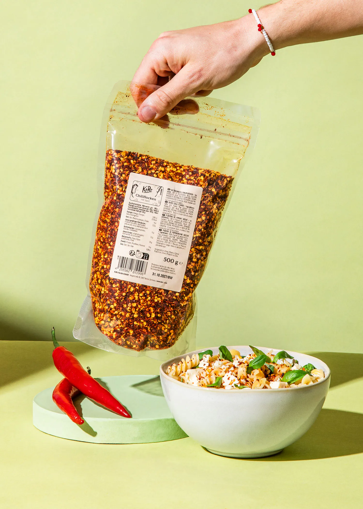 una persona sostiene una bolsa de popcorn junto a un tazón de palomitas de maíz