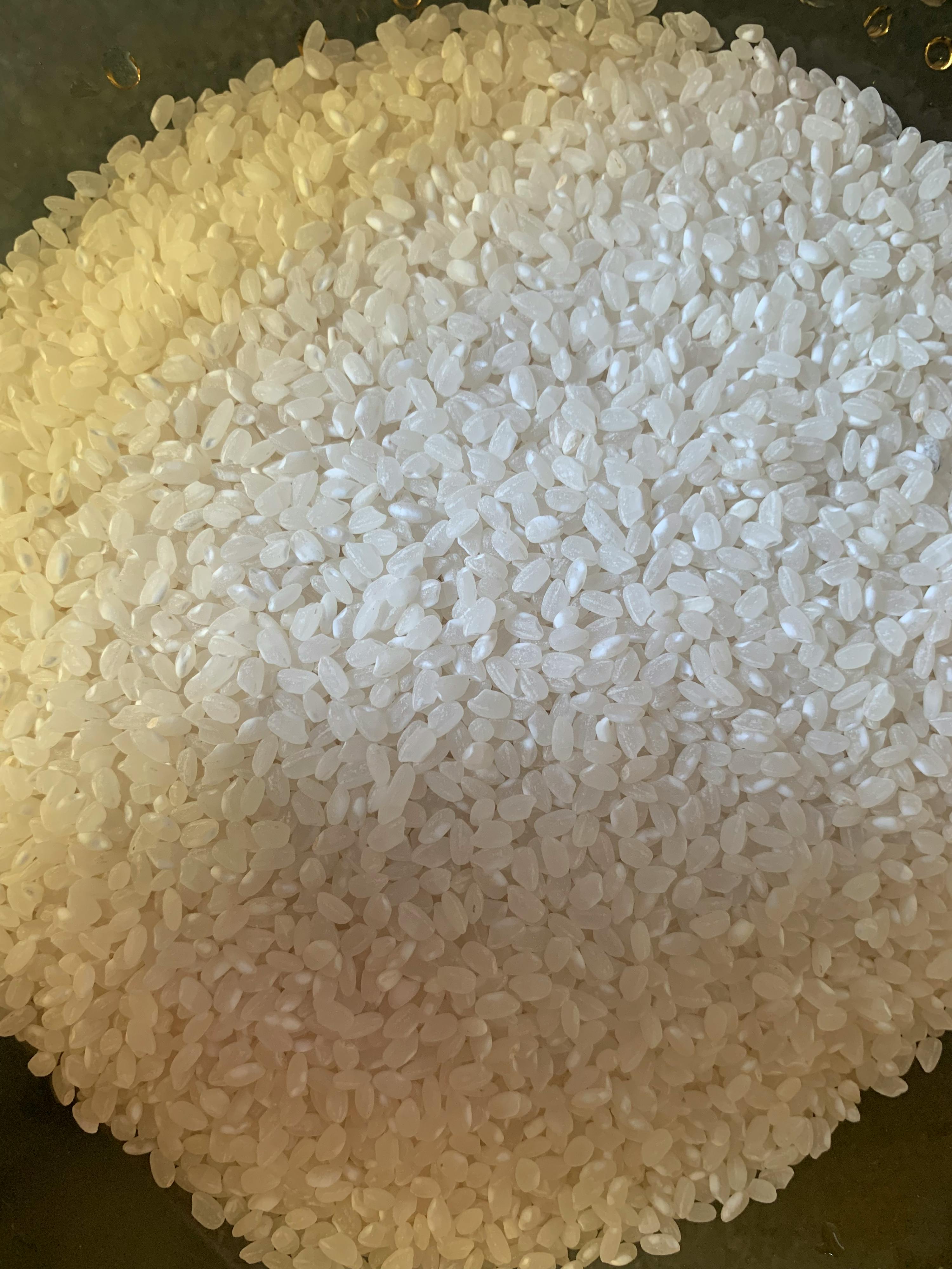 a pile of white rice on a black surface