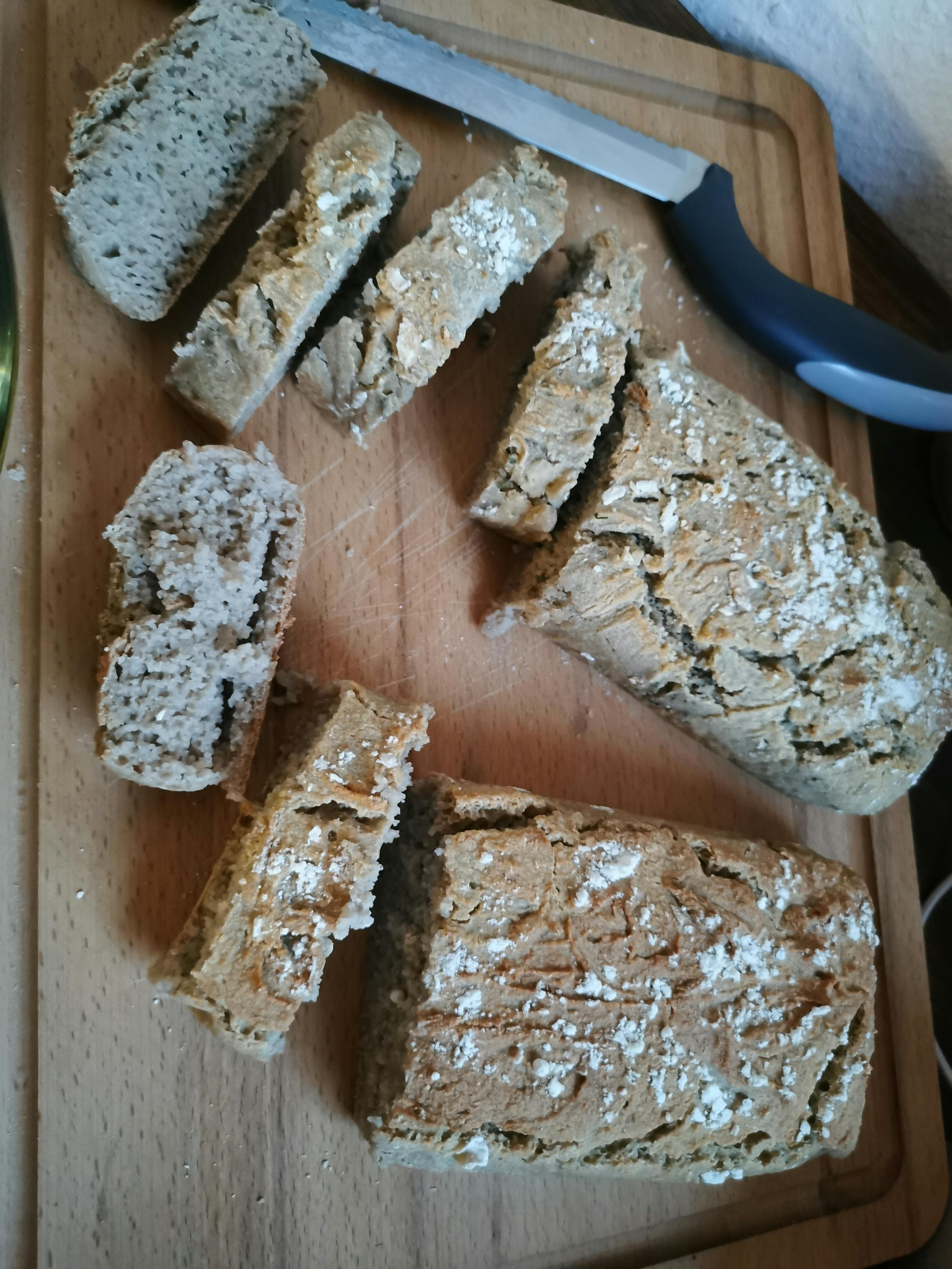 un pezzo di pane viene tagliato su un tagliere di legno