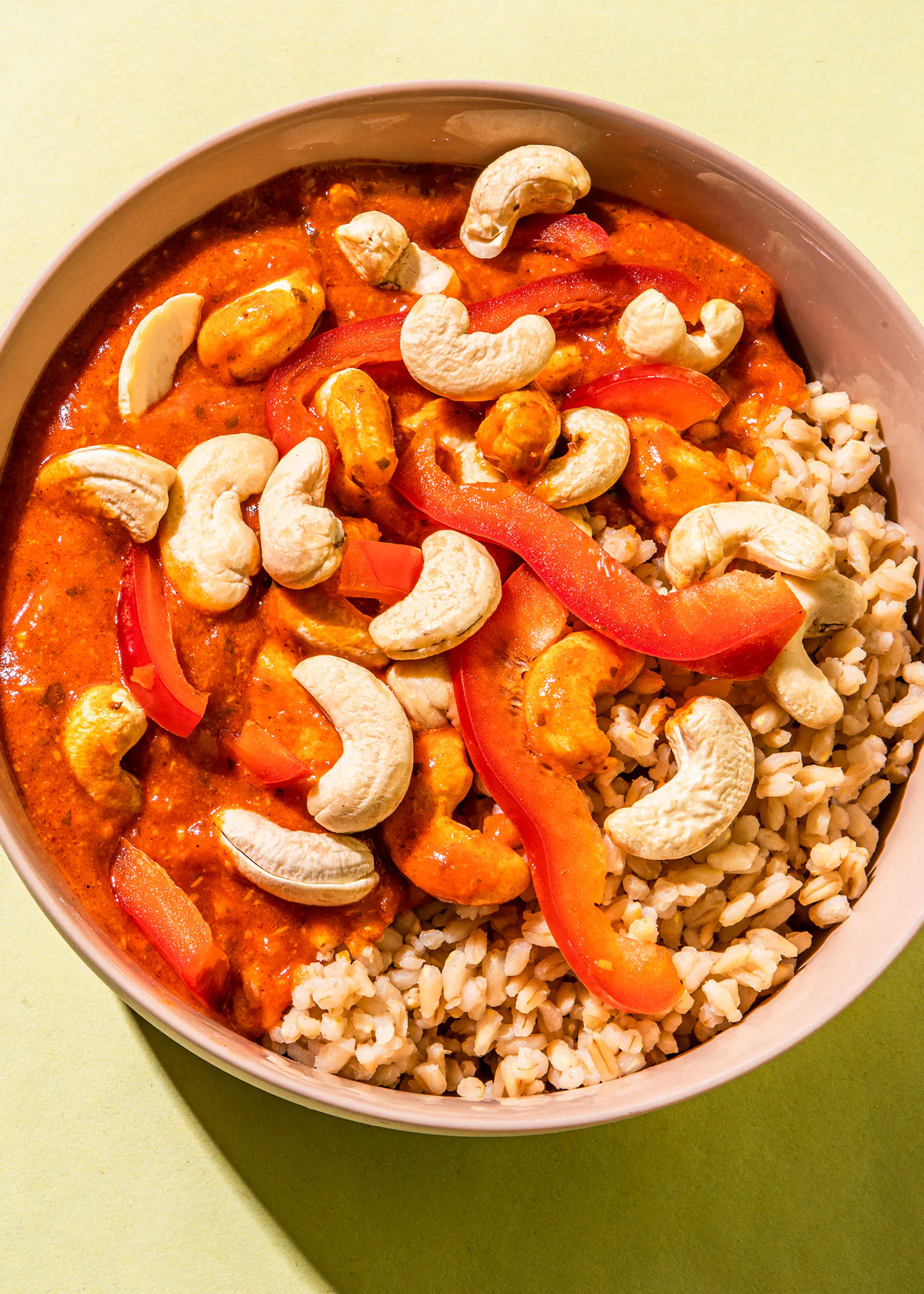 un bol de nourriture avec du riz et des noix de cajou sur une table