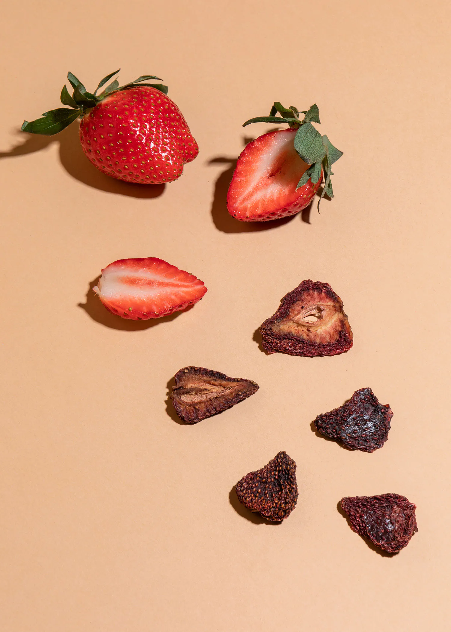 strawberries and dried strawberries on a beige surface