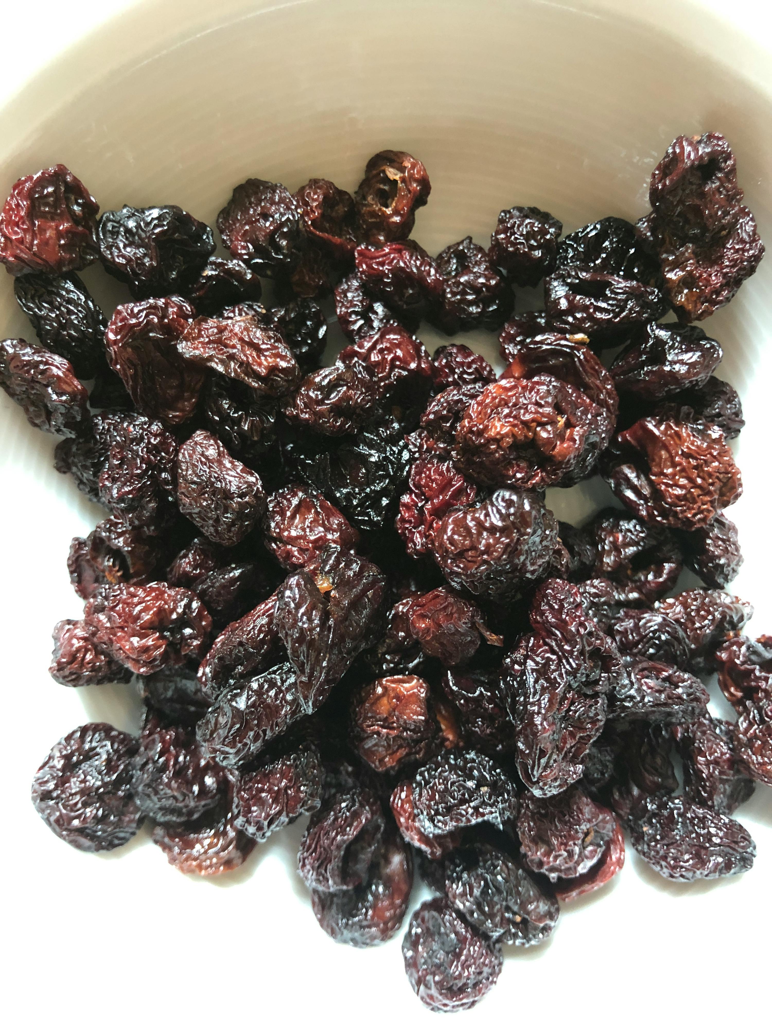un bol blanc rempli de pruneaux séchées