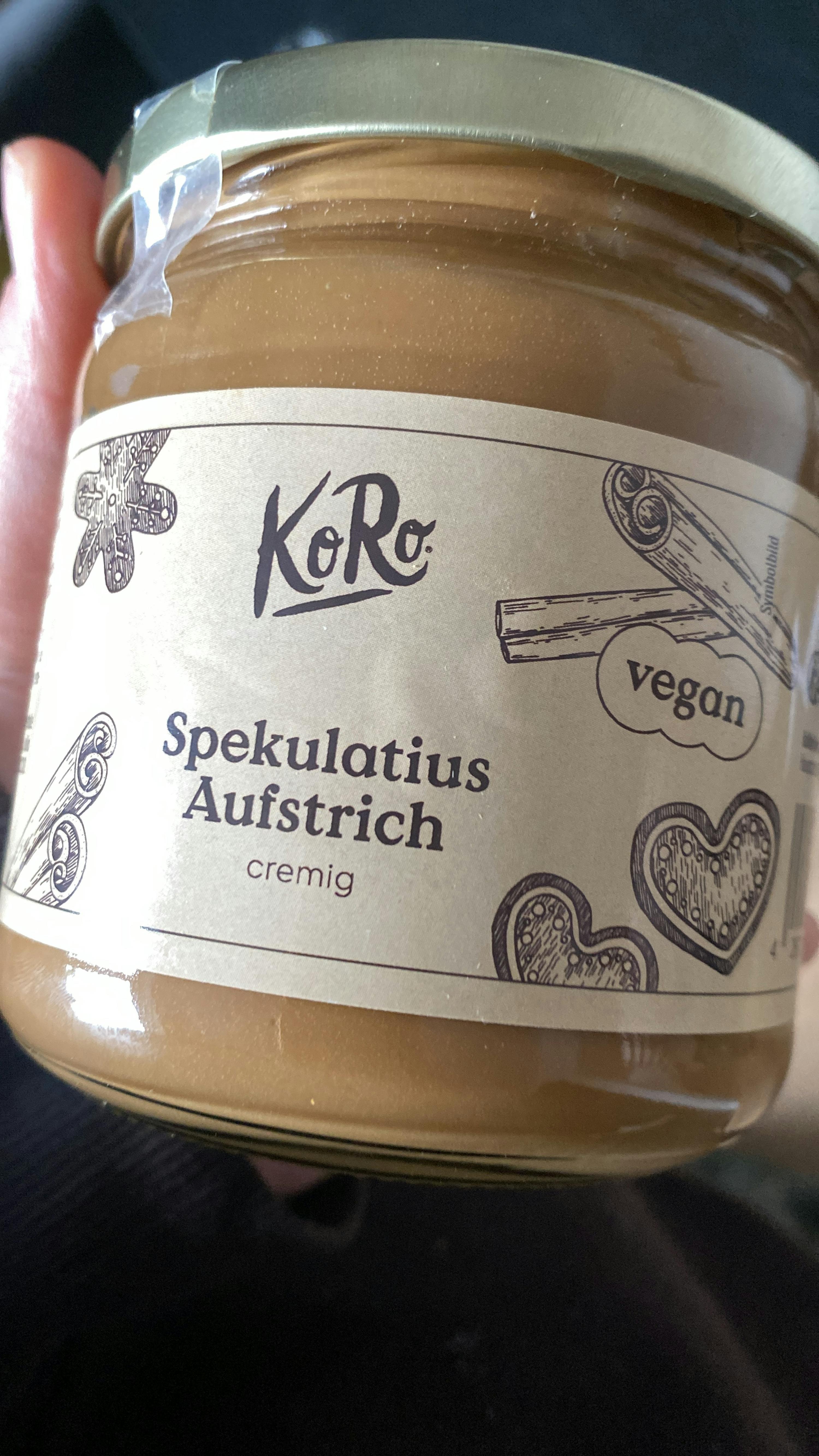 a person is holding a jar of cinnamon spread that is vegan
