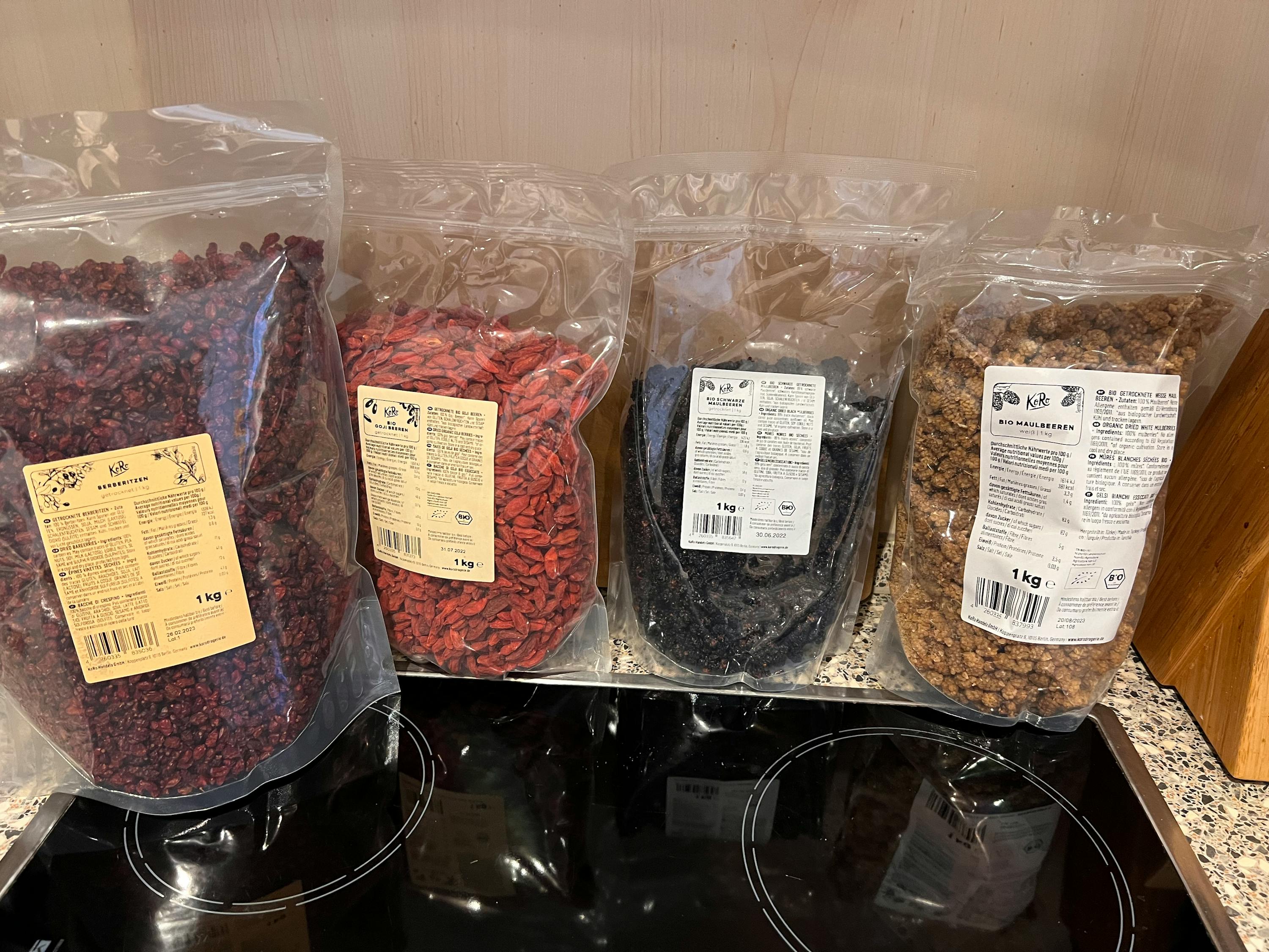 vier Plastiktüten mit verschiedenen Lebensmitteln stehen auf einem Herd