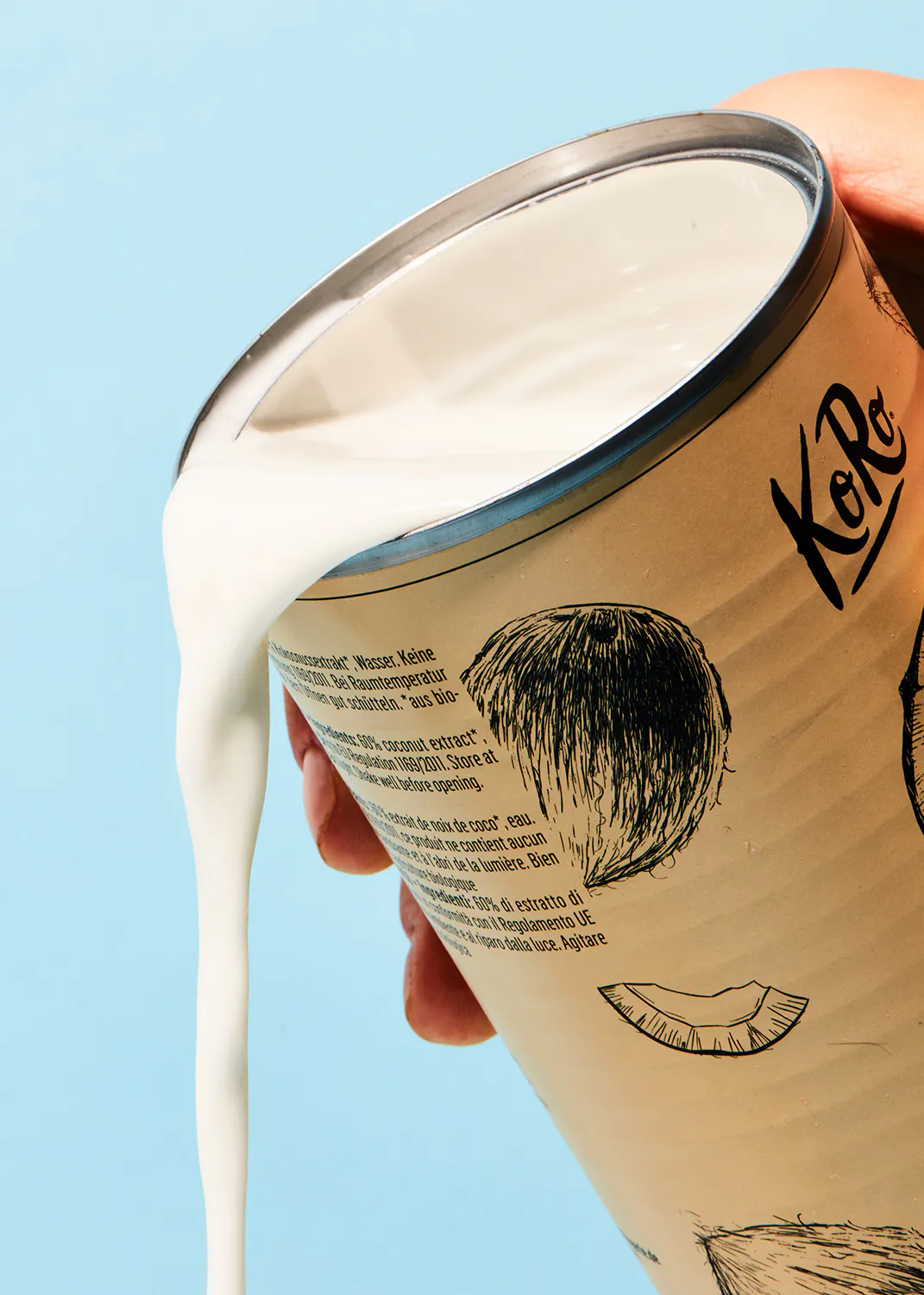 une personne verse du lait d' une boîte à côté d' un dessin d' une noix de coco