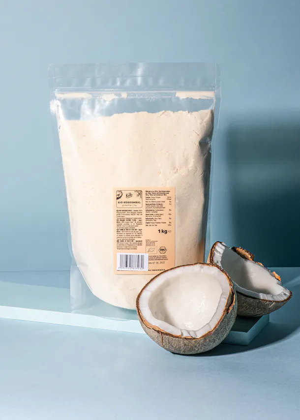a bag of coconut flour is next to a half of a coconut