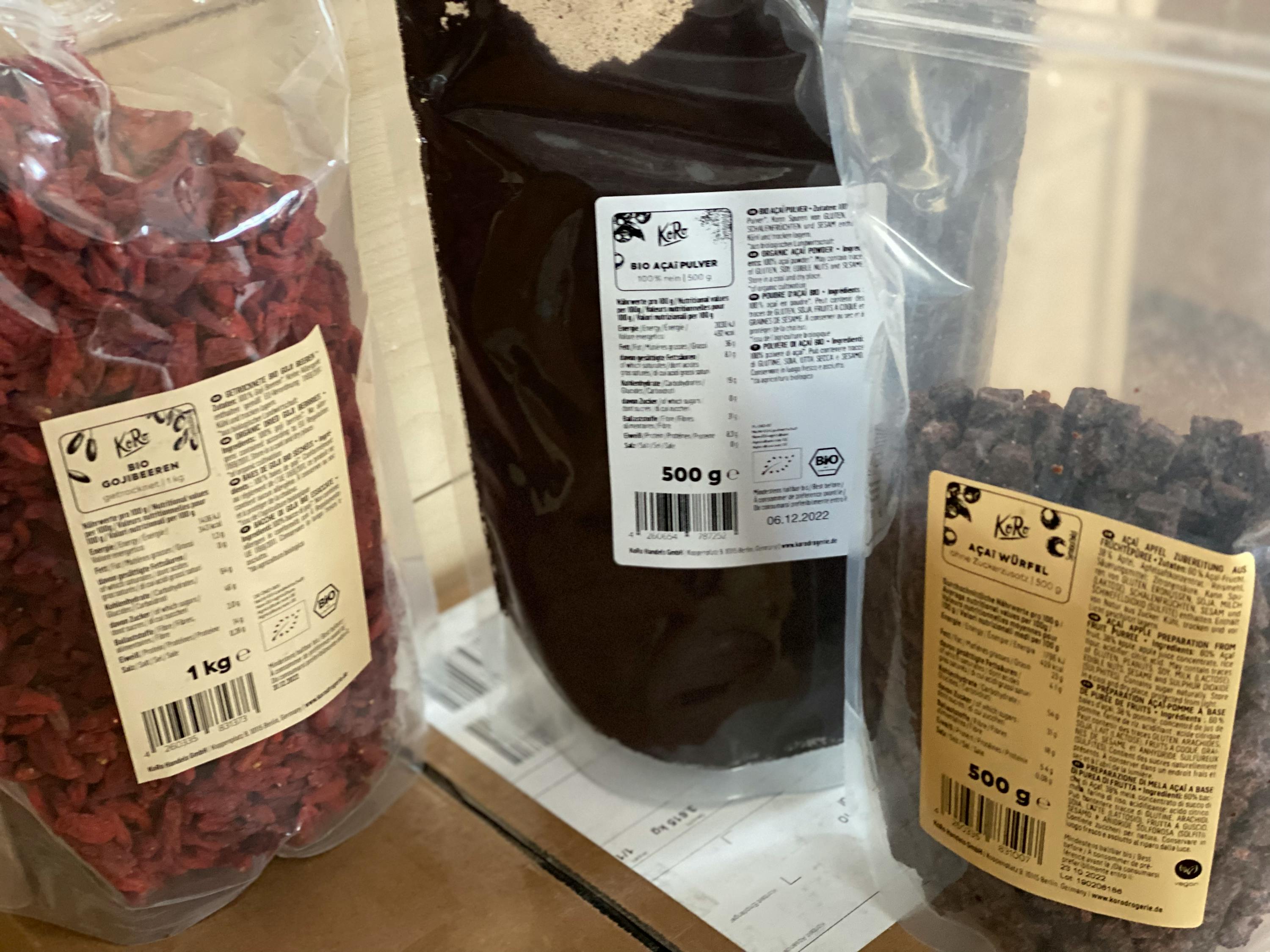 a bag of goji berries sits next to a bag of cocoa powder