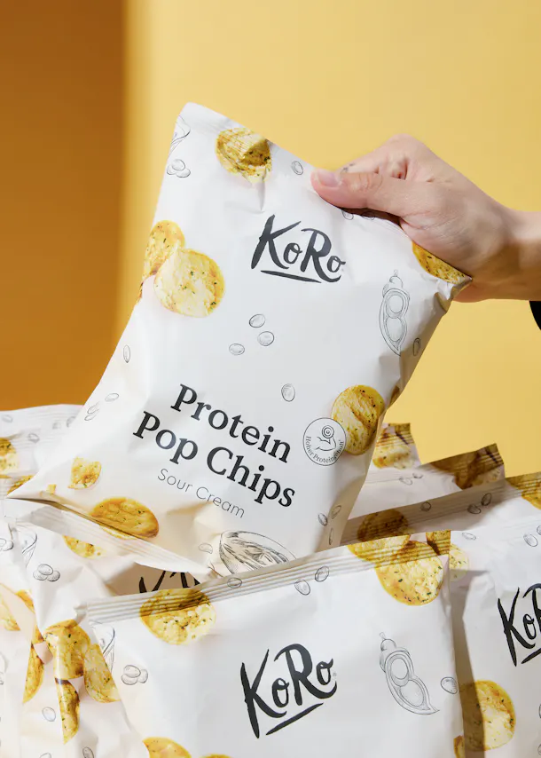 une personne tient un sac de chips pop protéinées