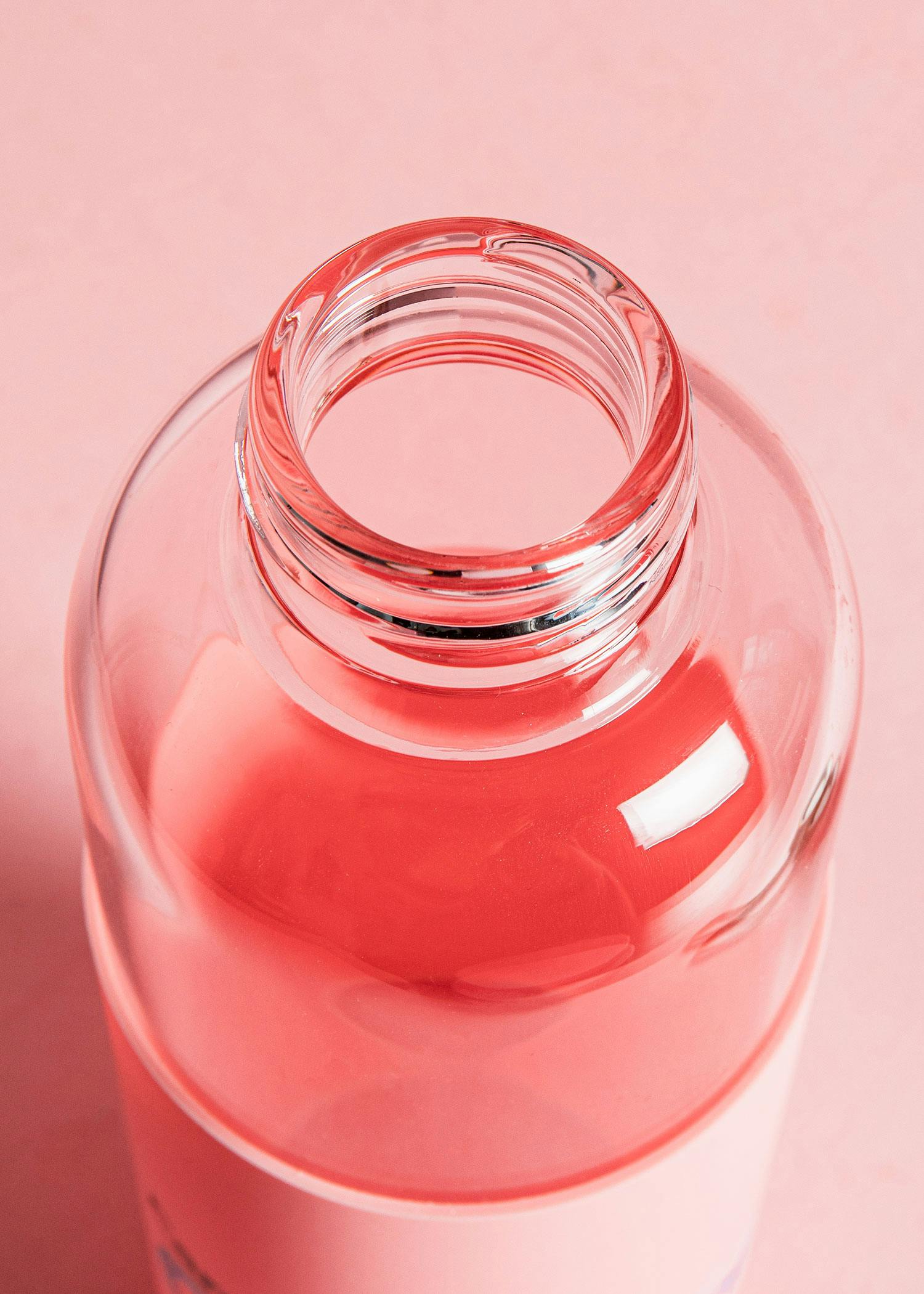 a glass bottle with a pink liquid in it