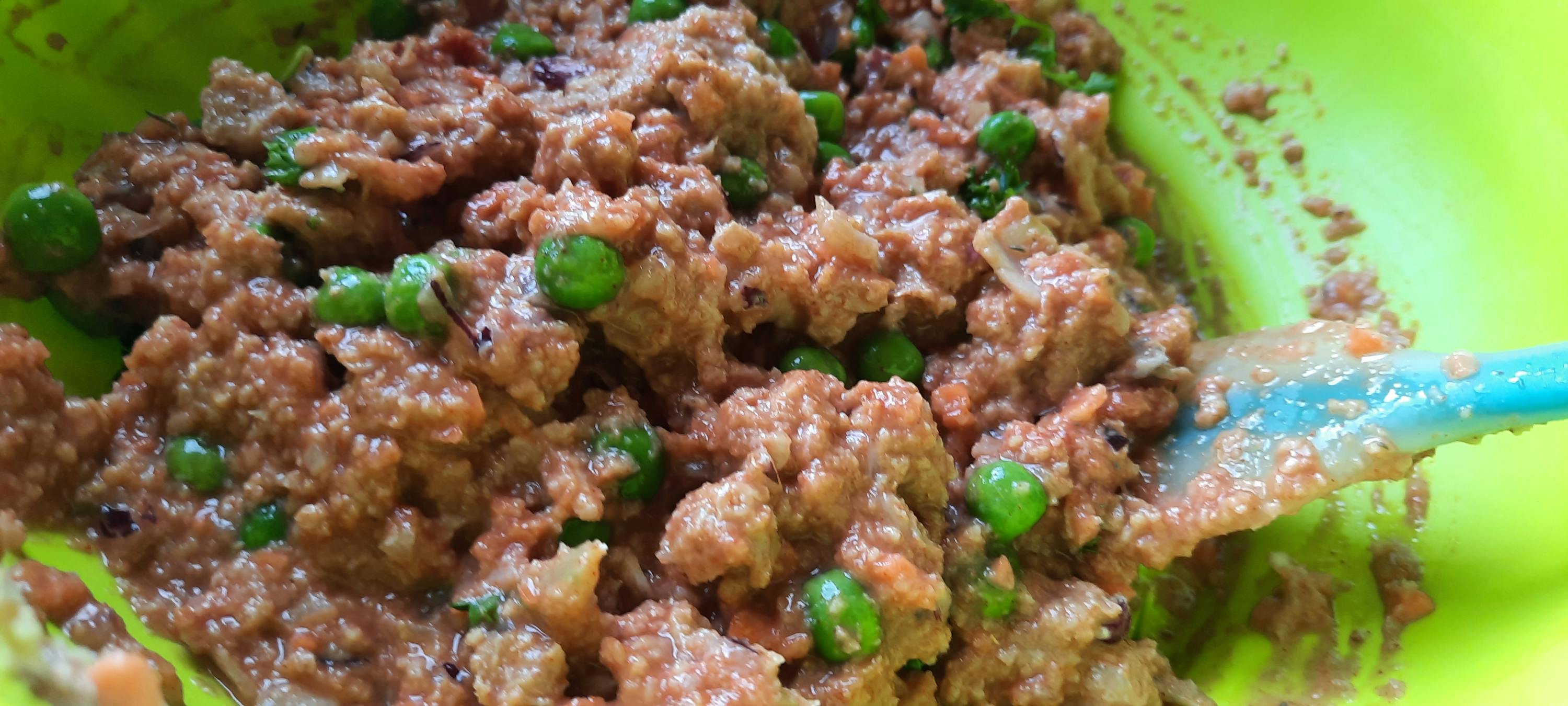 eine Nahaufnahme einer Schüssel mit Fleisch und Erbsen