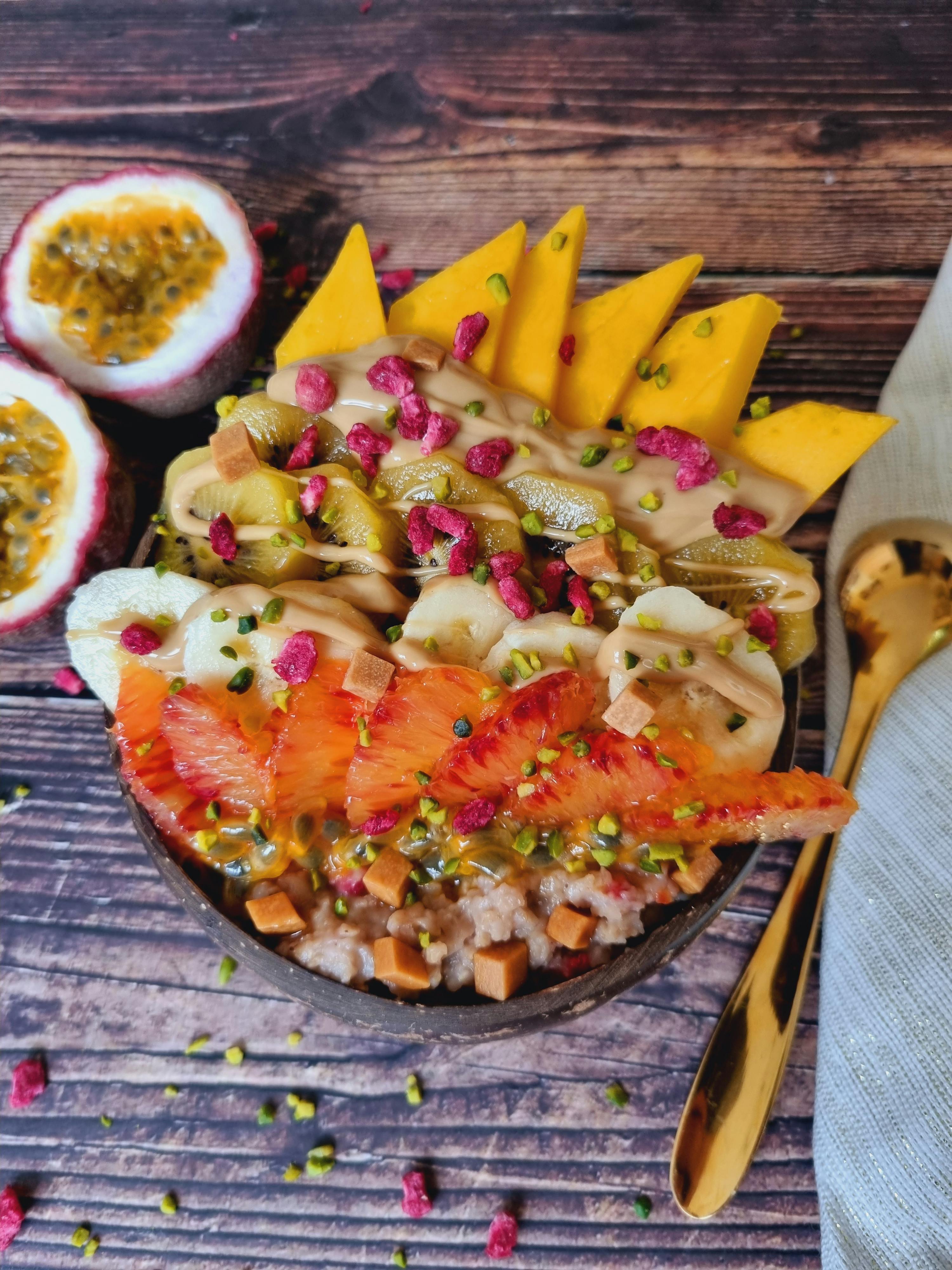 a bowl of oatmeal with fruit and nuts on a wooden table