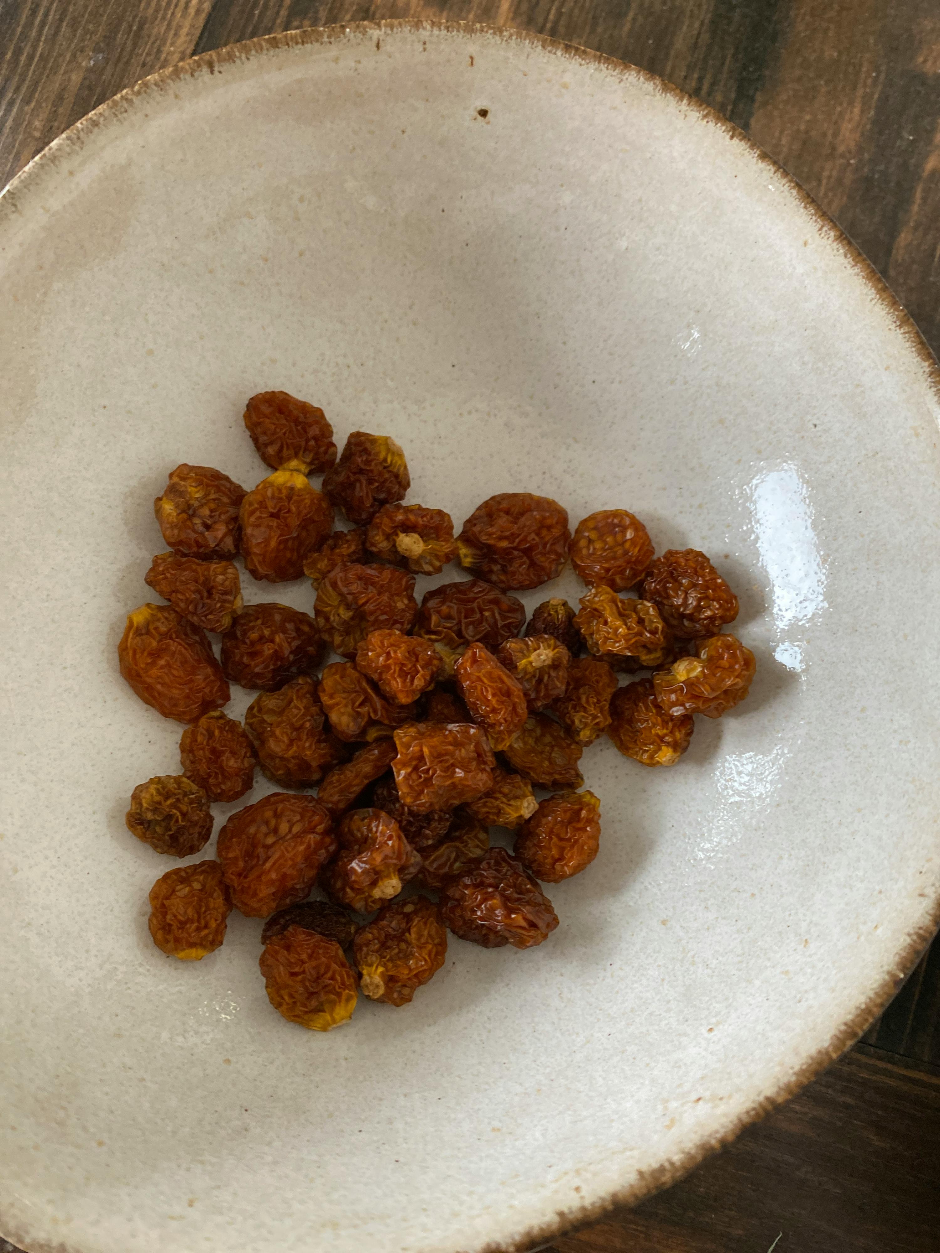 eine weiße Schüssel mit getrockneten Früchten auf einem Tisch