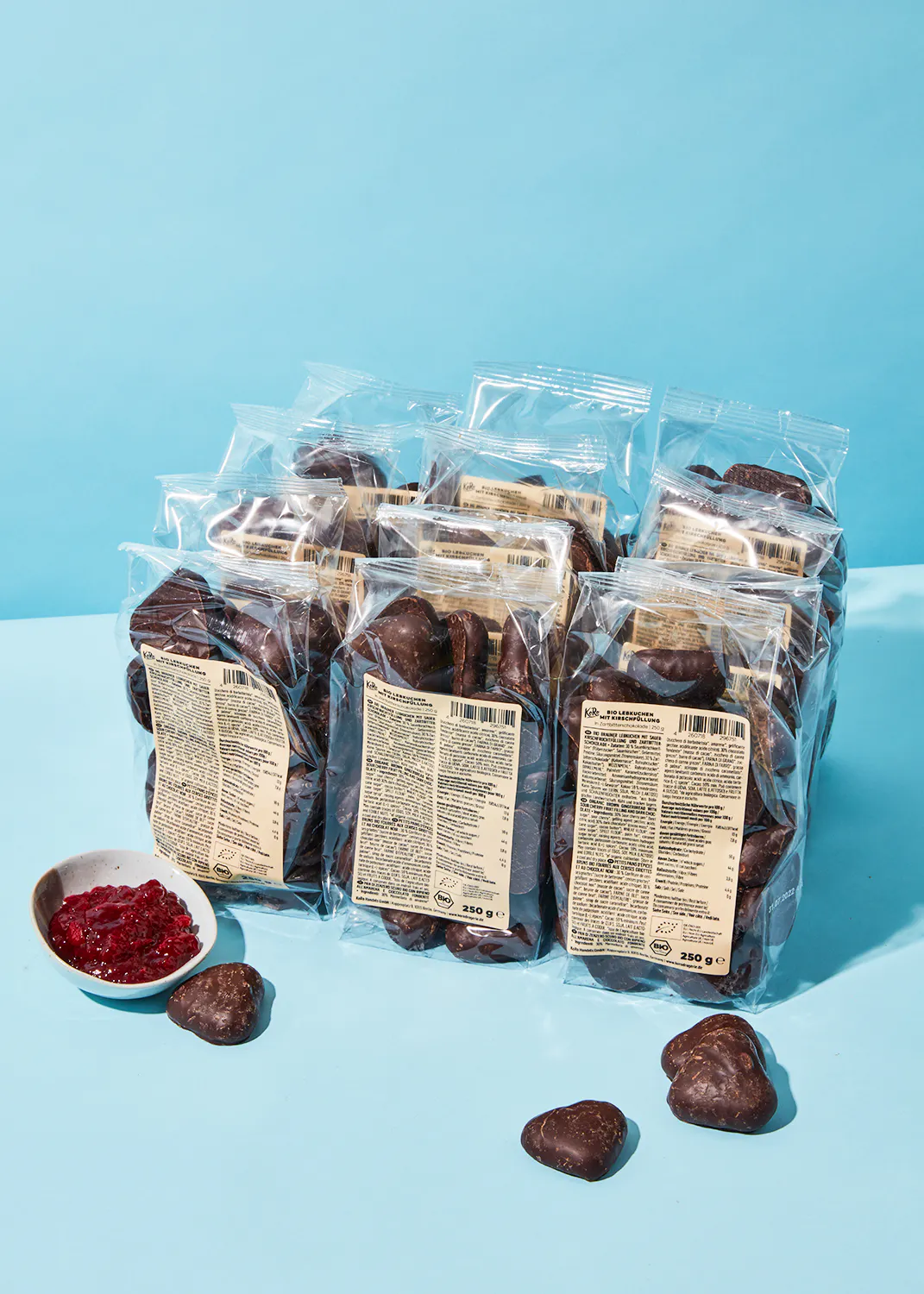 several bags of chocolate covered cookies are stacked on top of each other on a blue surface