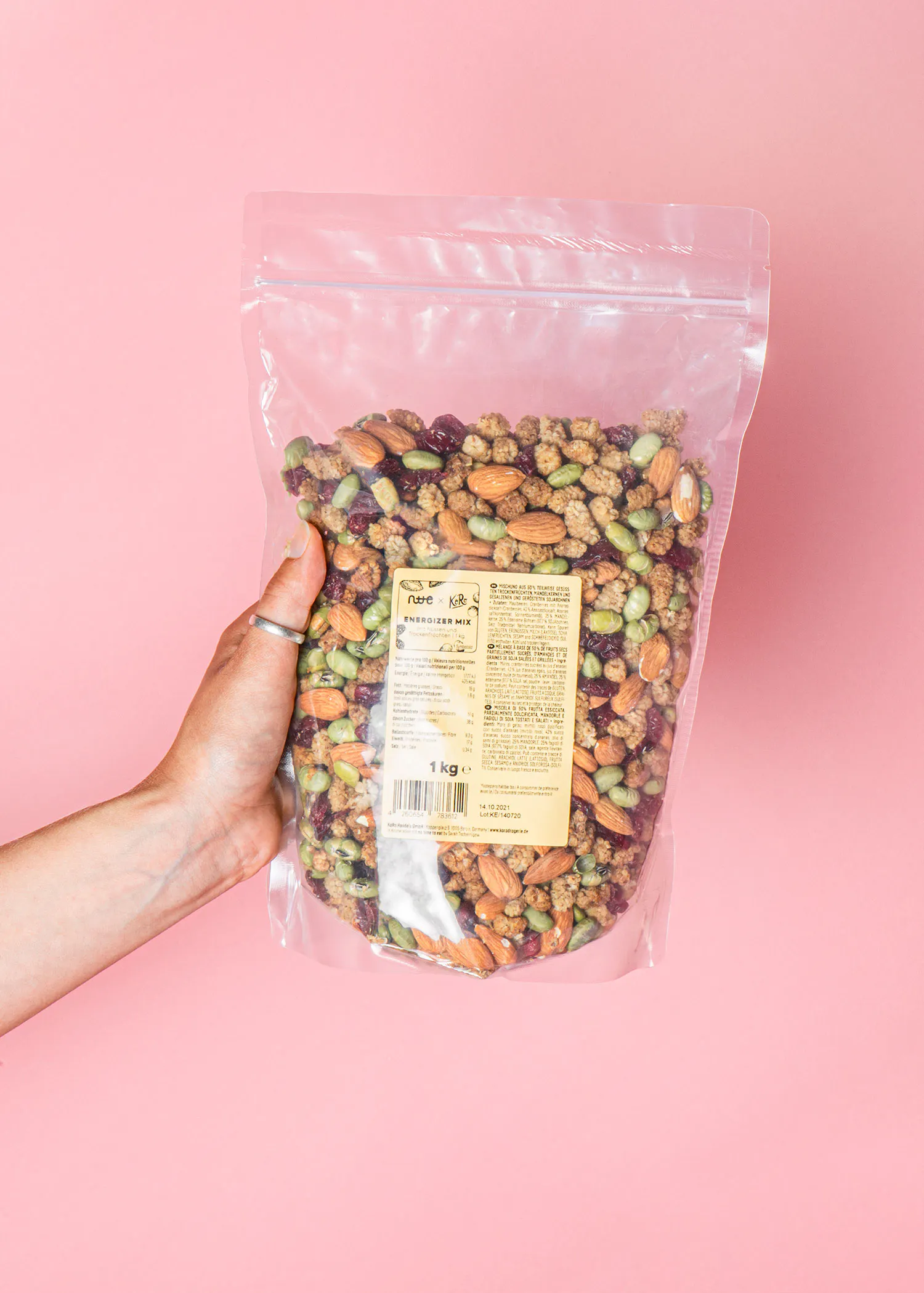 une personne tient un sac de nourriture sur fond rose