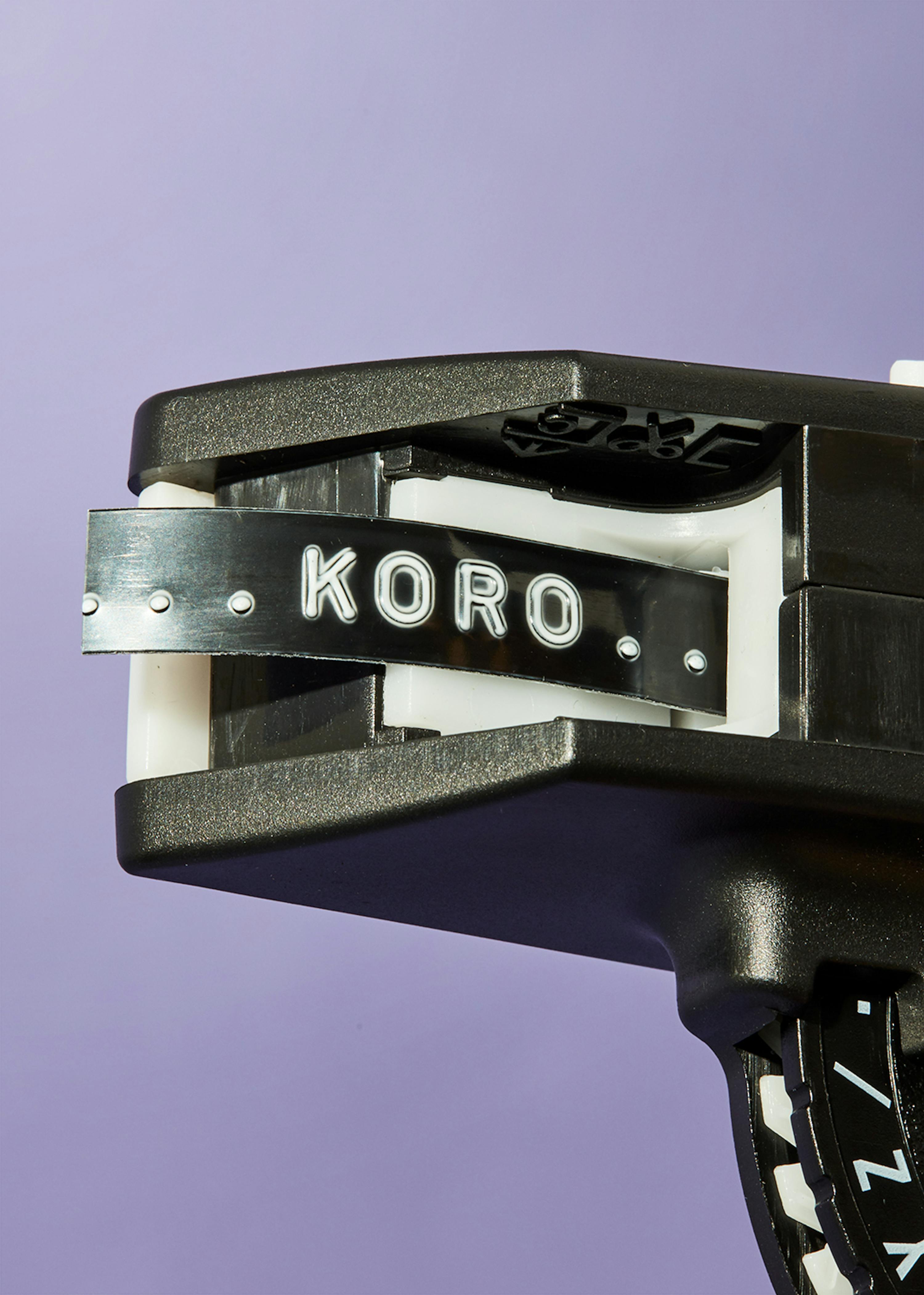 a close up of a koro tape dispenser on a purple background