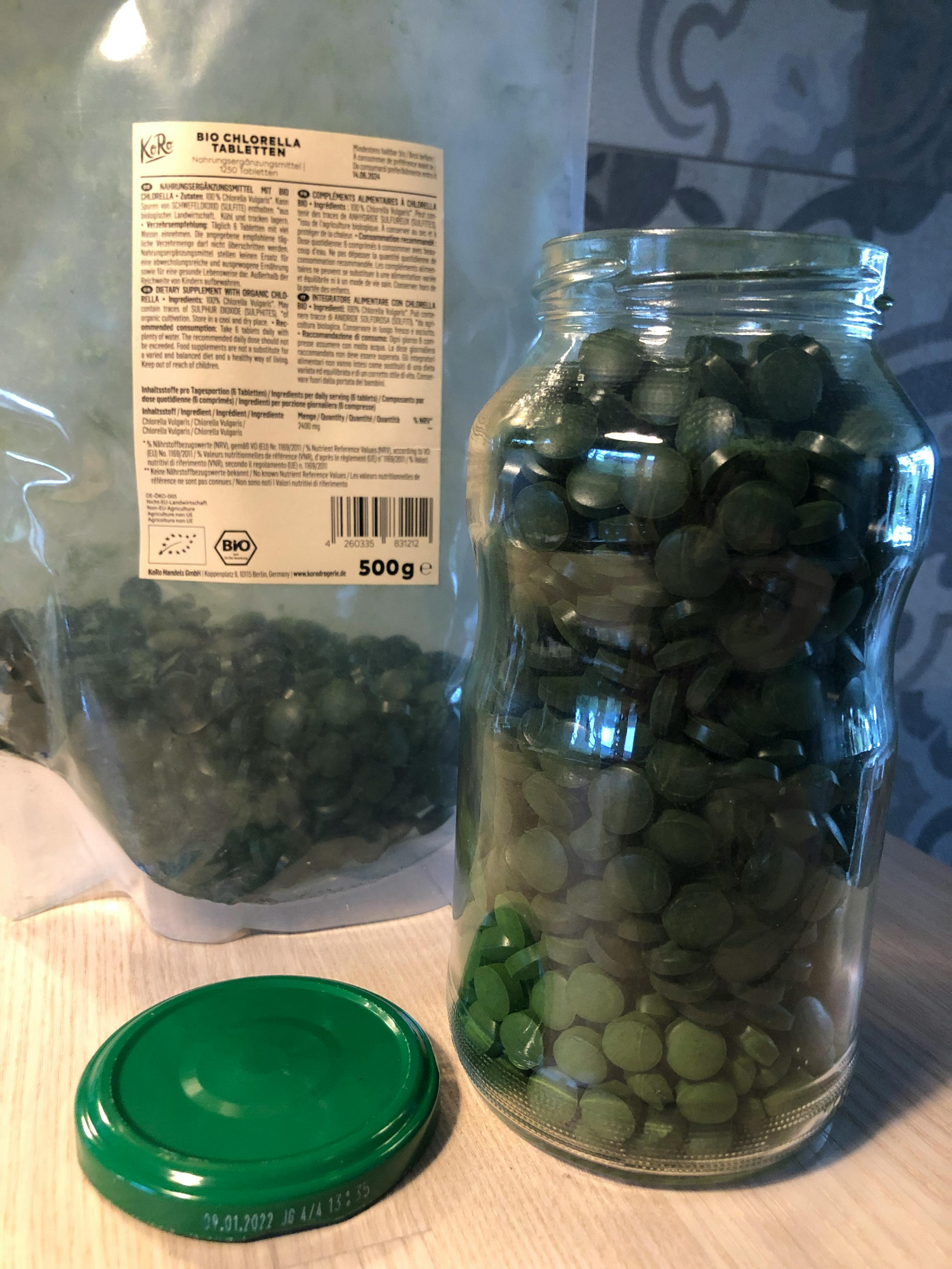 un bocal en verre rempli de pilules vertes et un sac de 500g de pilules vertes