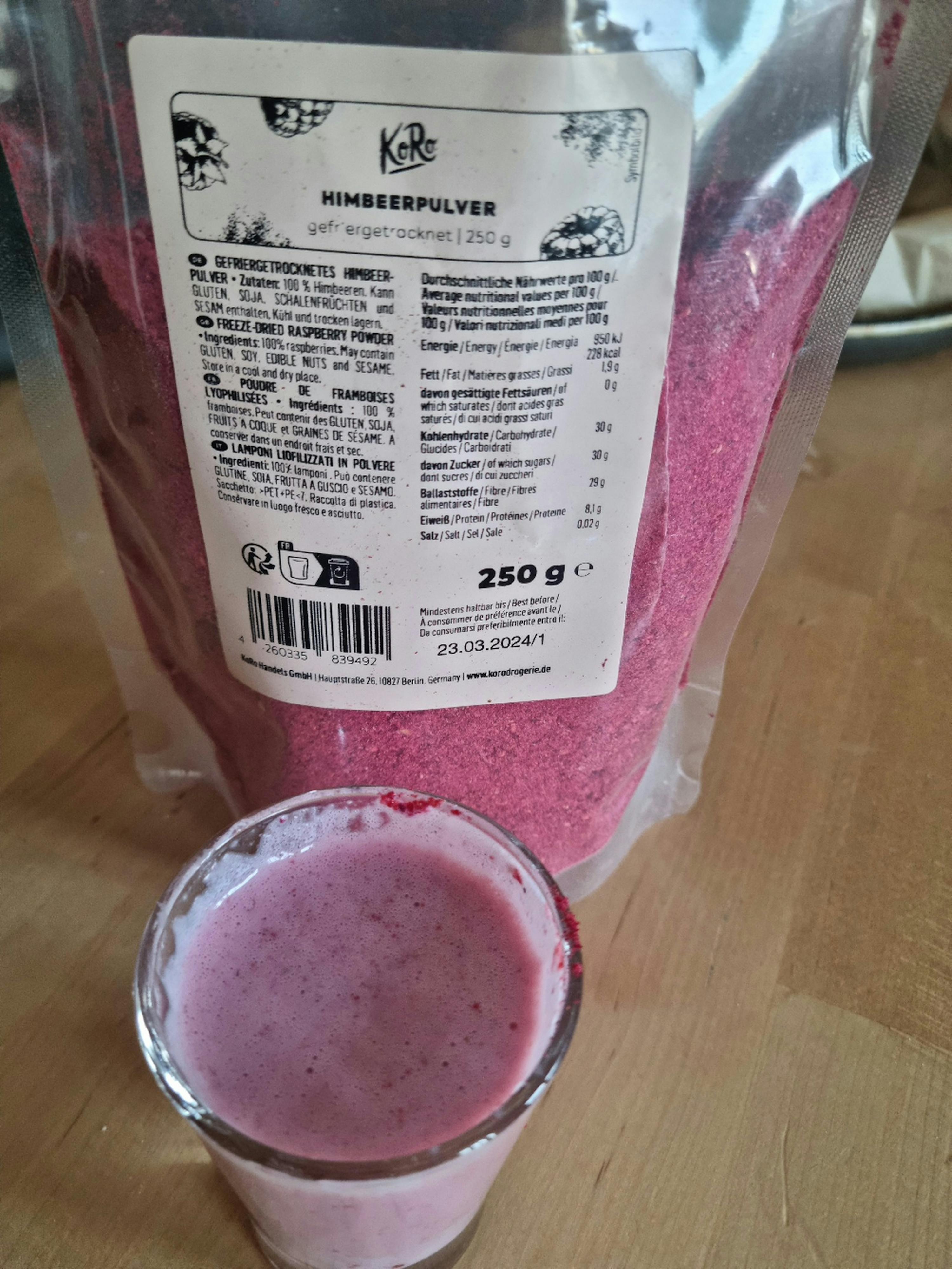 a bag of raspberry powder is next to a shot glass