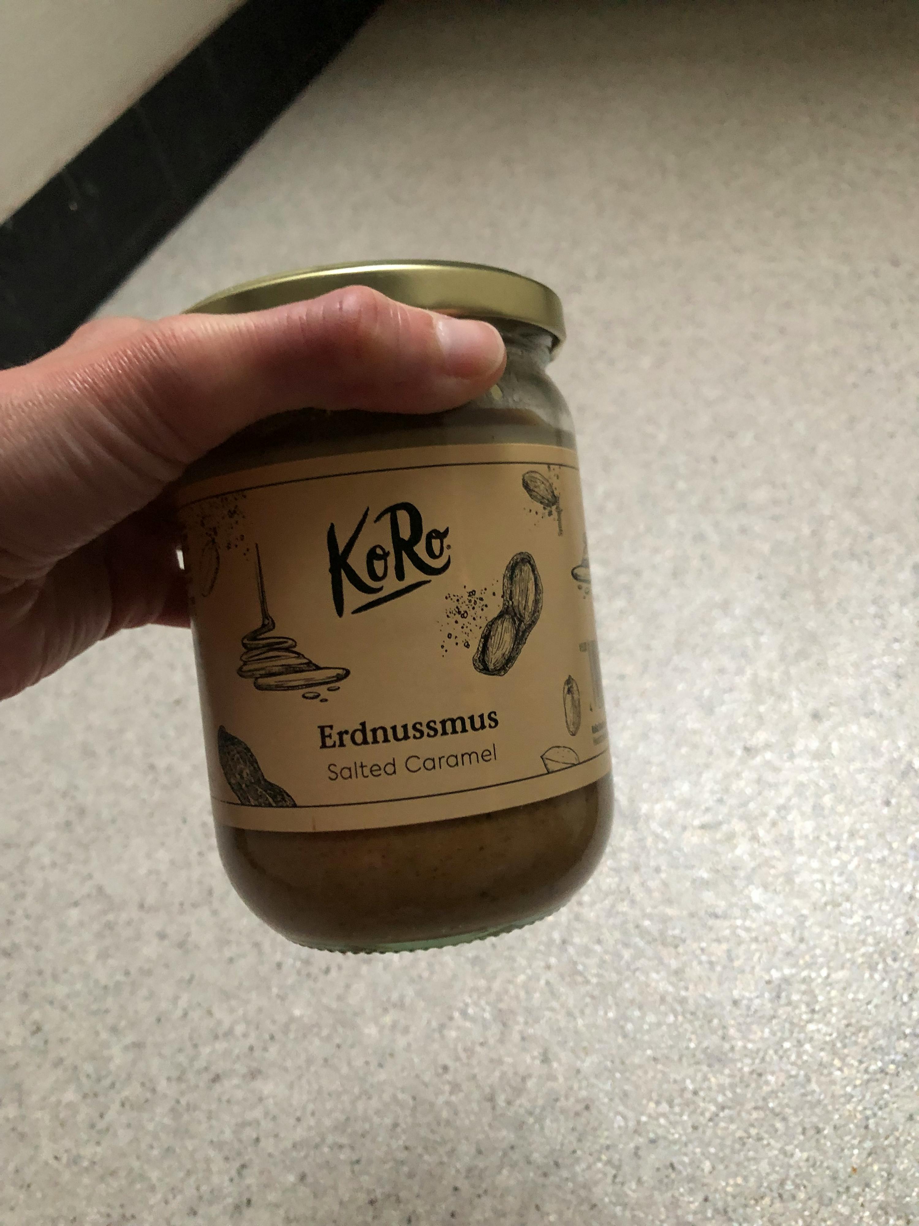 una persona tiene in mano un barattolo di peanut butter con caramello salato