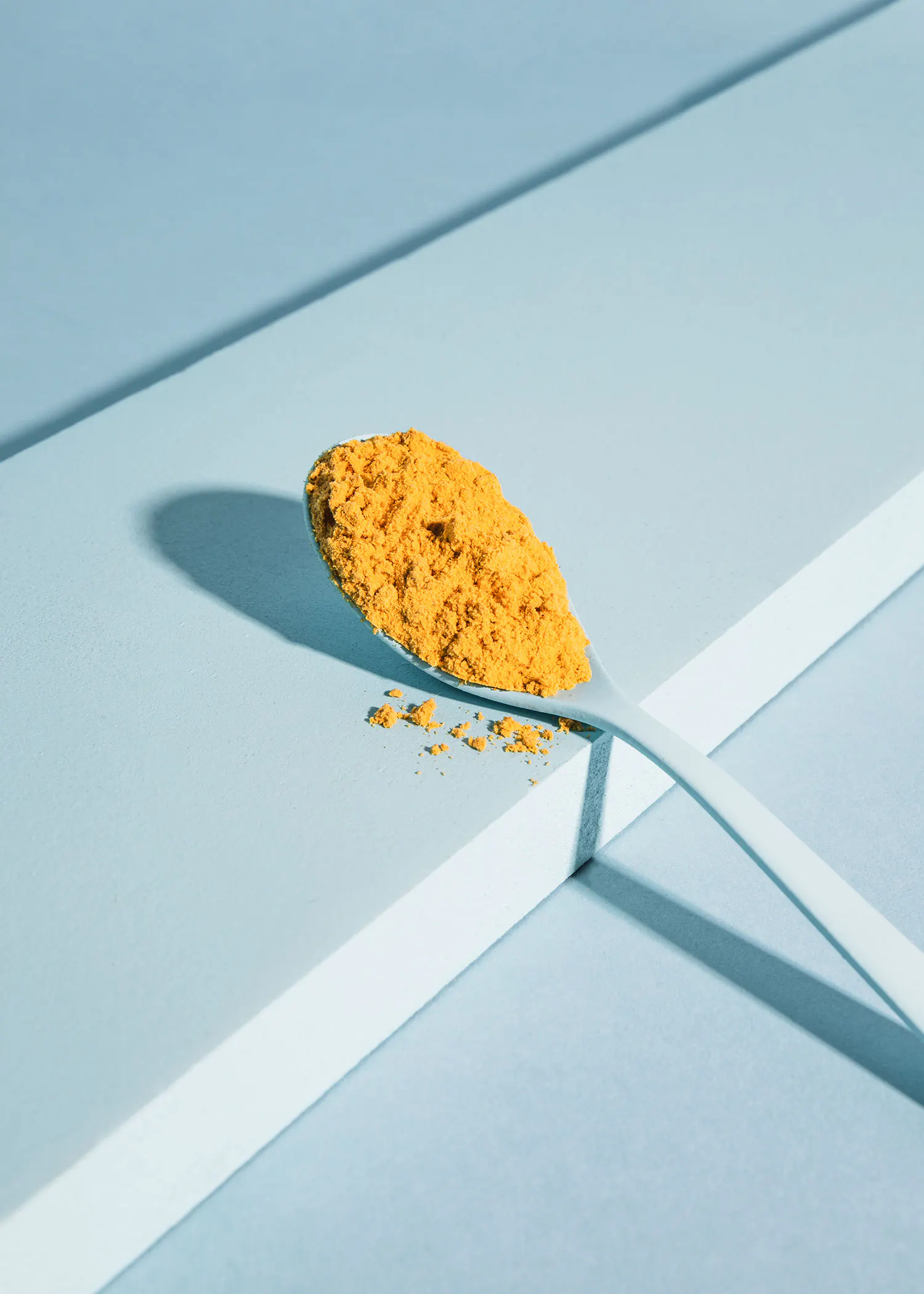 ein Löffel mit gelbem Pulver liegt auf einem Tisch