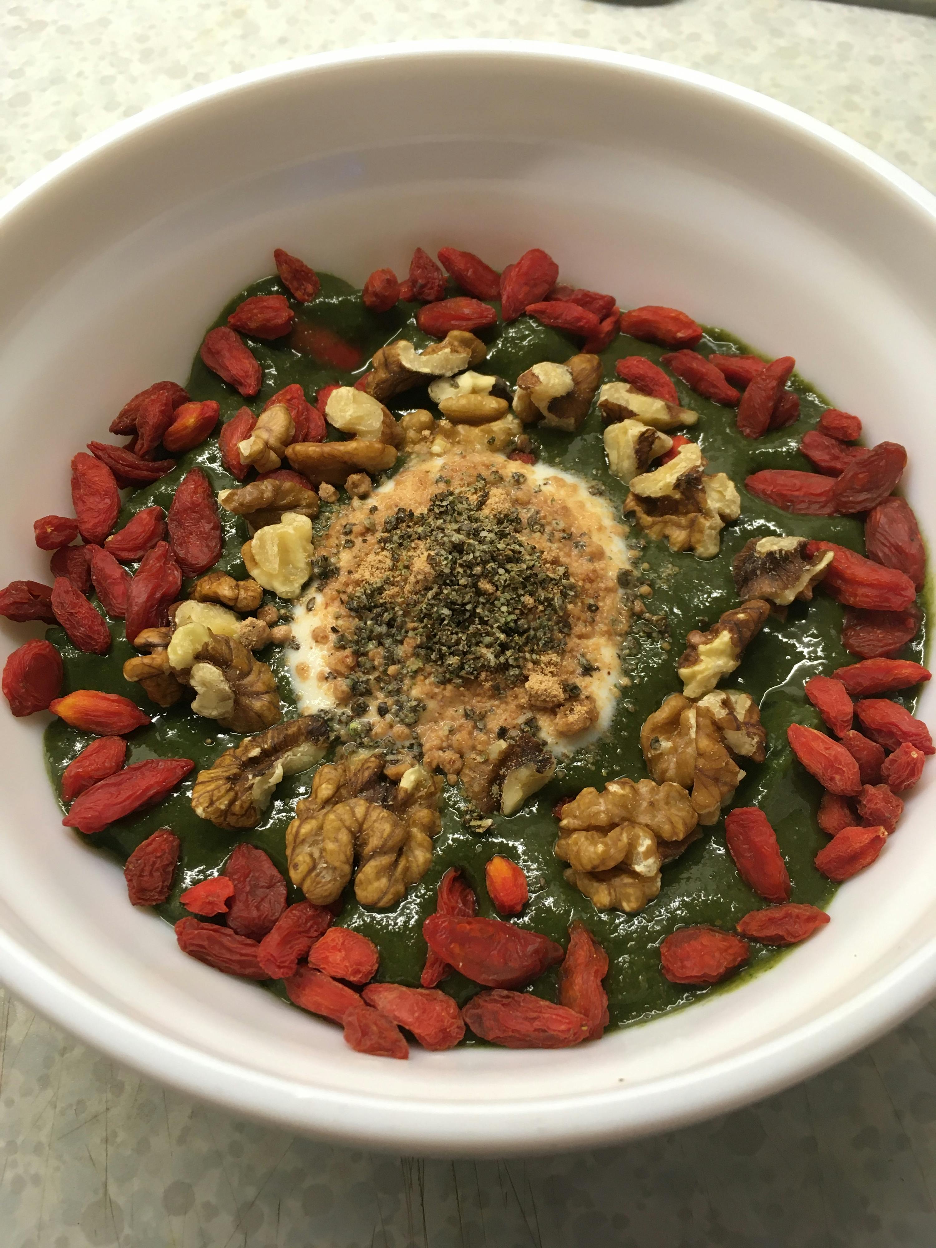 a bowl of food with nuts and berries on top