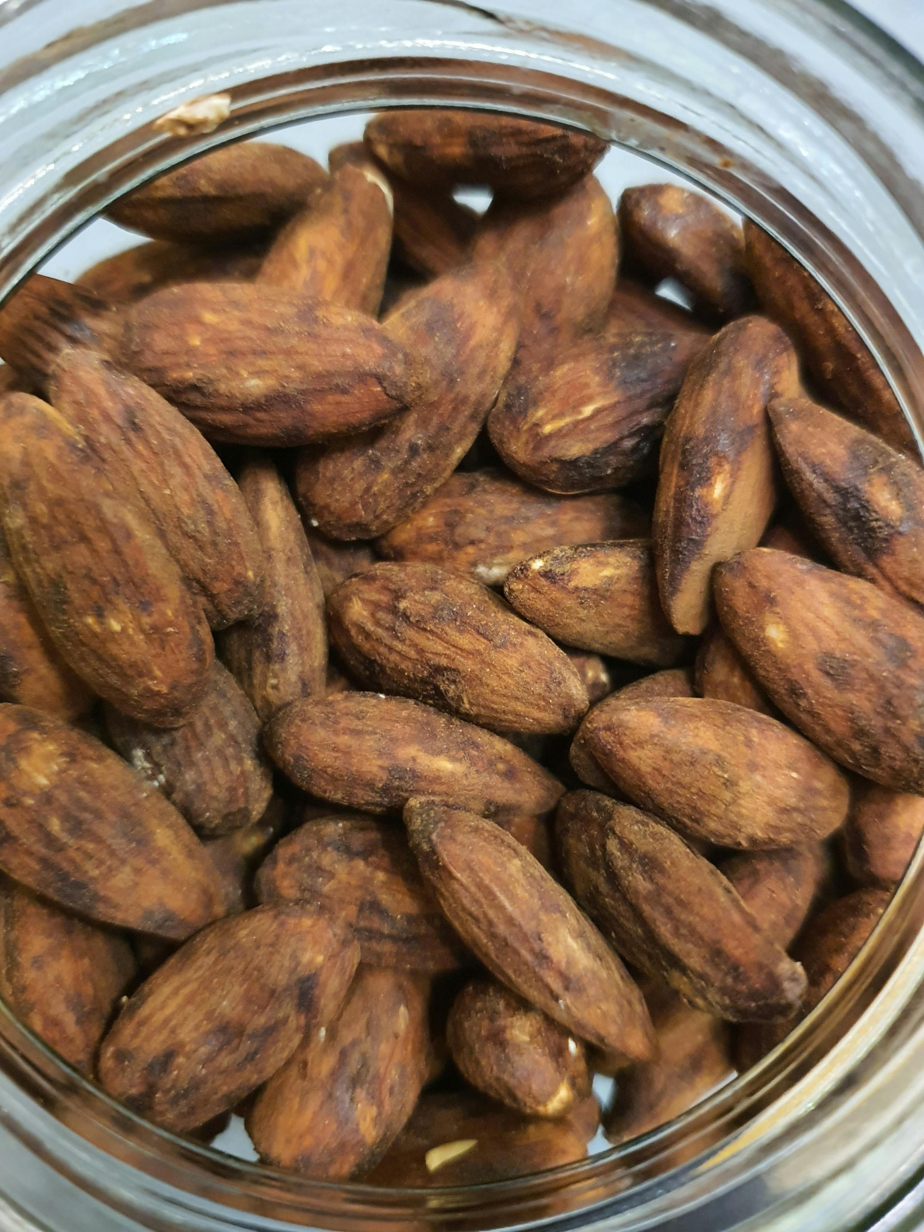 eine Nahaufnahme von gerösteten Mandeln in einem Glasgefäß