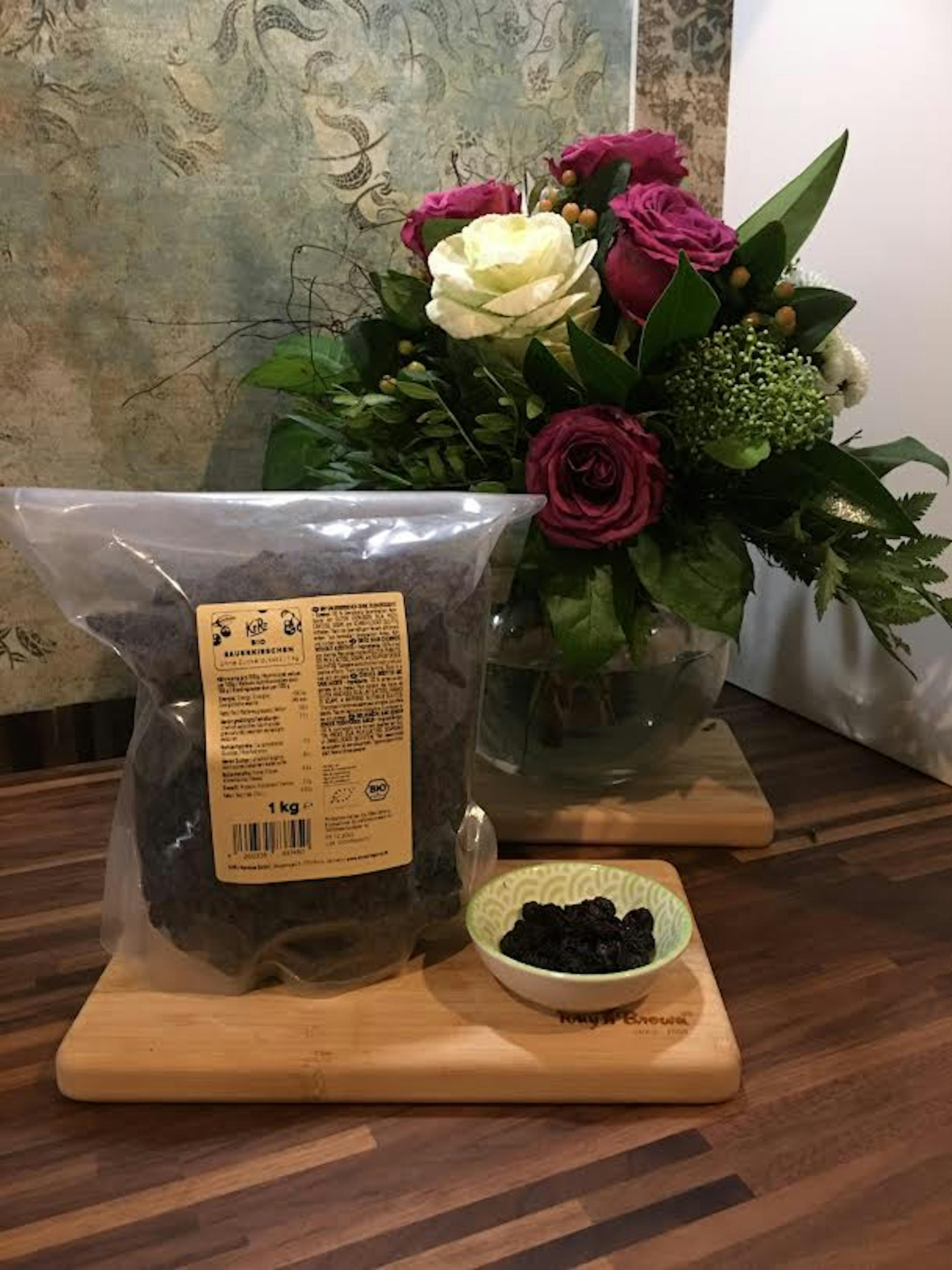 un sac de raisins assis sur une planche à découper en bois à côté d' un bol de raisins