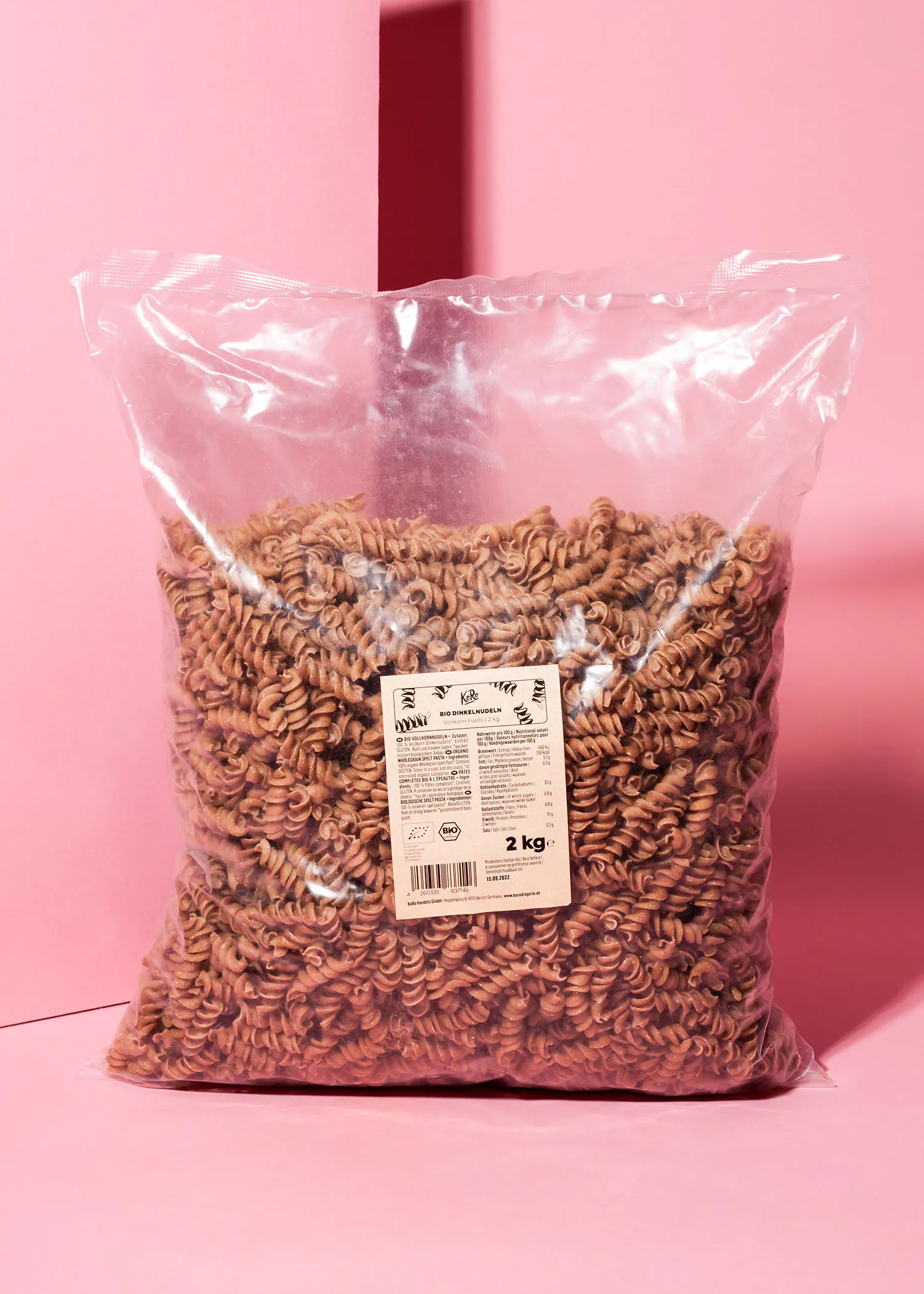 a bag of pasta is sitting on a pink surface