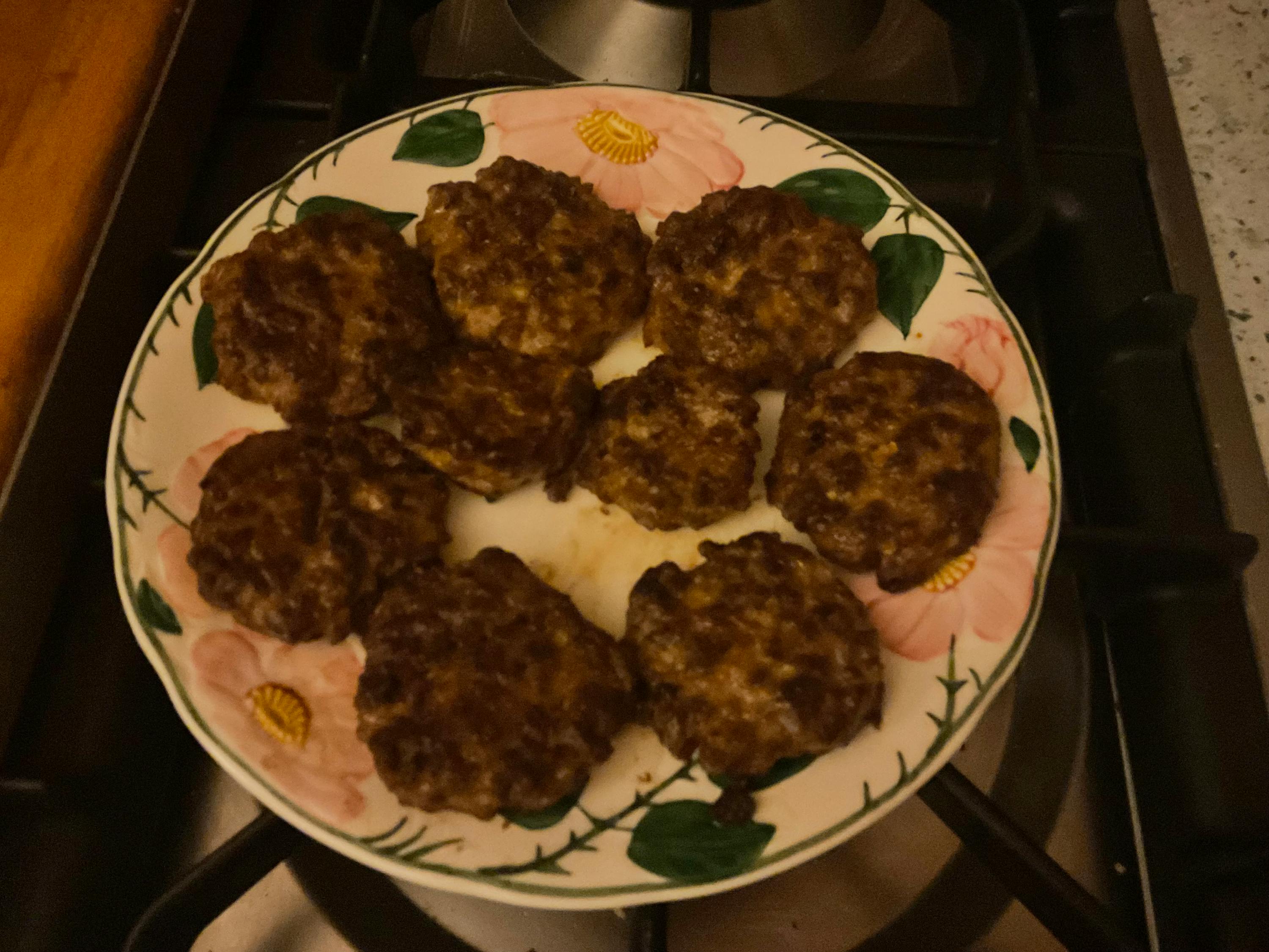 ein weißer und grüner Teller mit einem floralen Design auf einem Herd