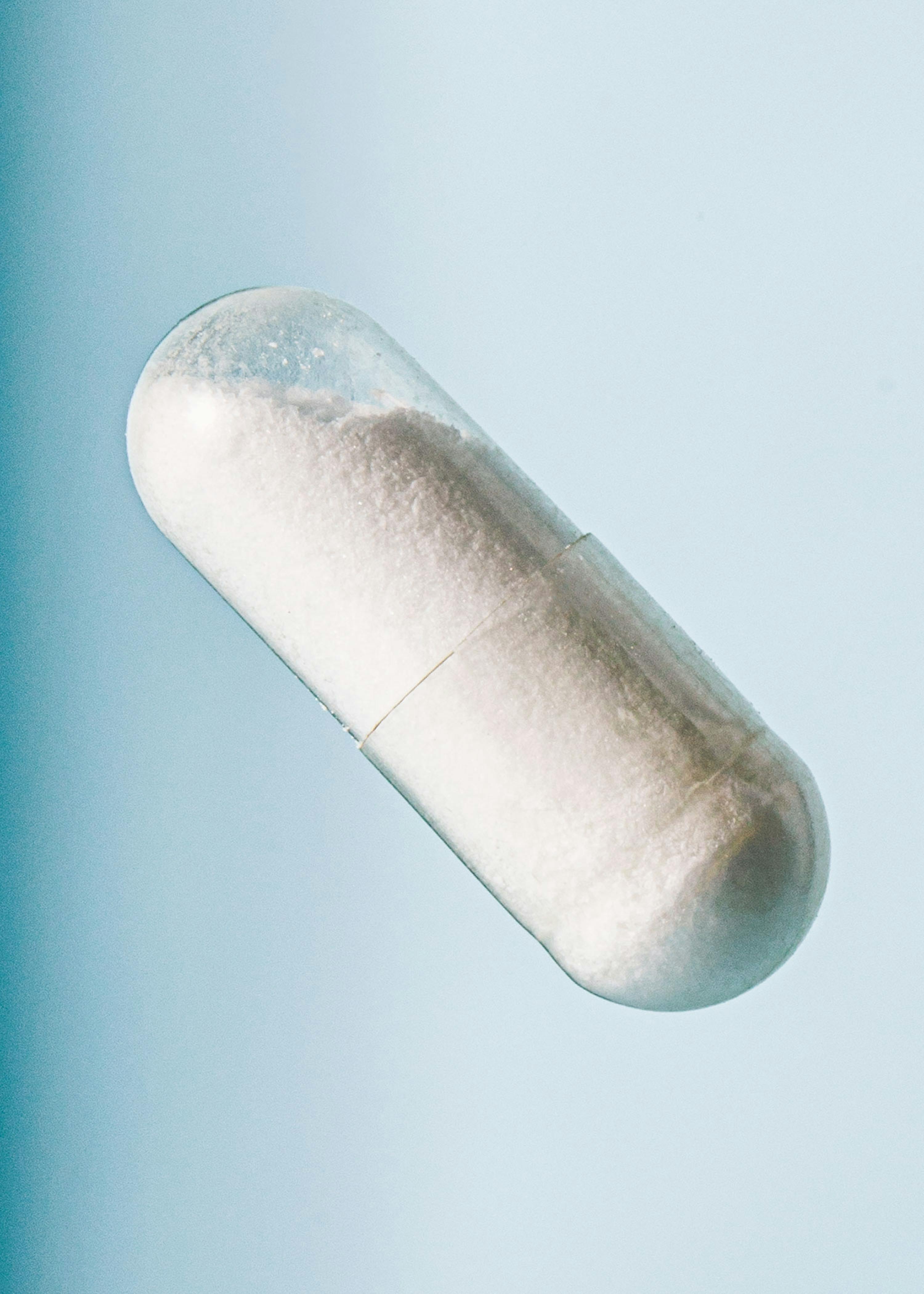 a clear capsule with white powder inside of it