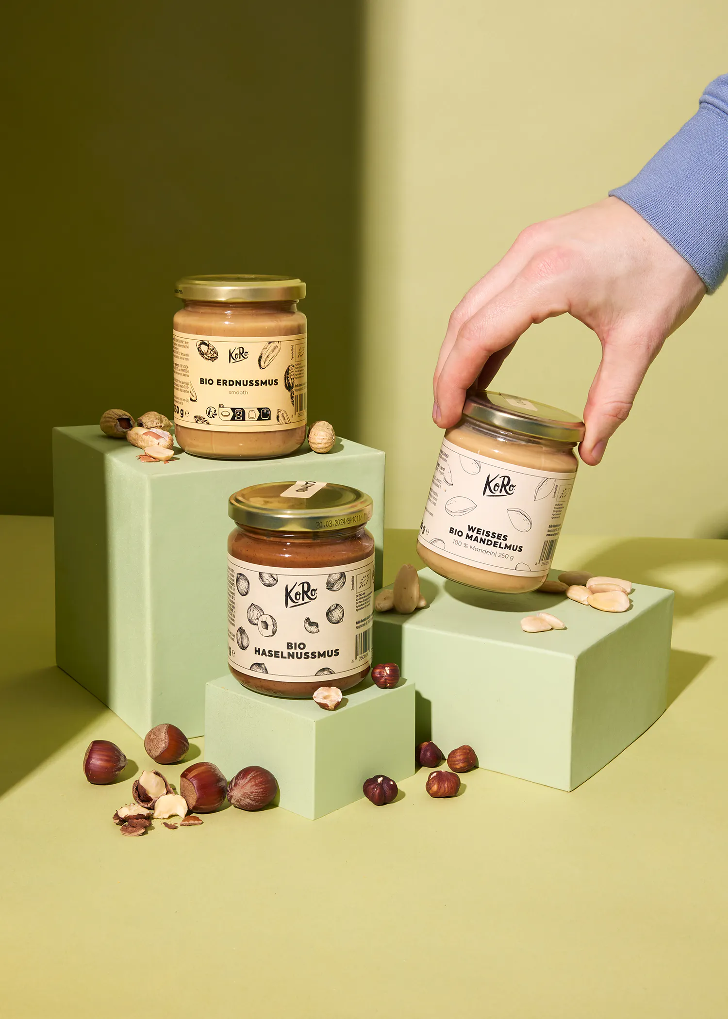 trois bocaux de beurre d' arachide sont posés sur des blocs verts