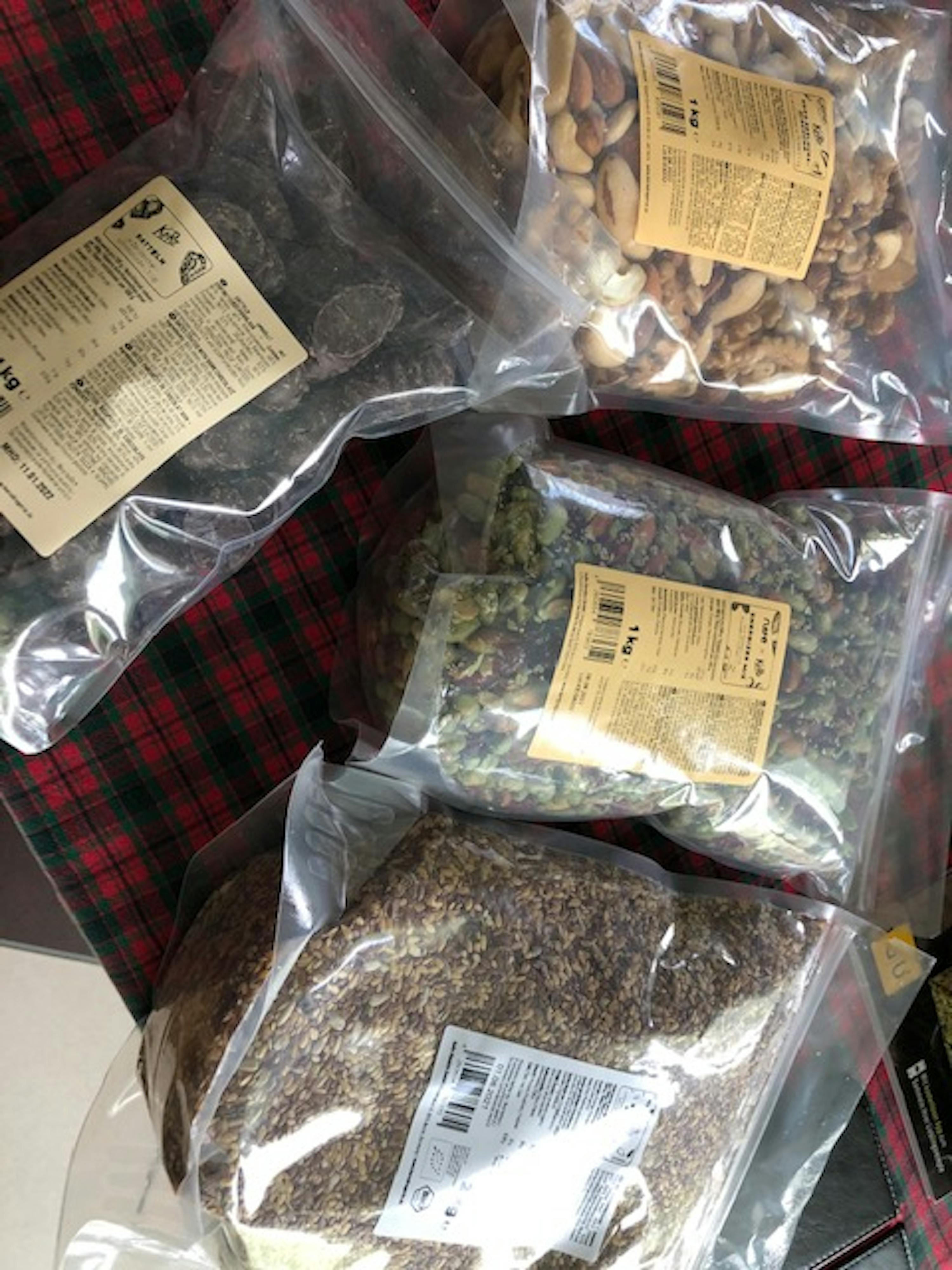 quattro sacchetti di cibo sono seduti uno accanto all'altro su un tavolo a quadri