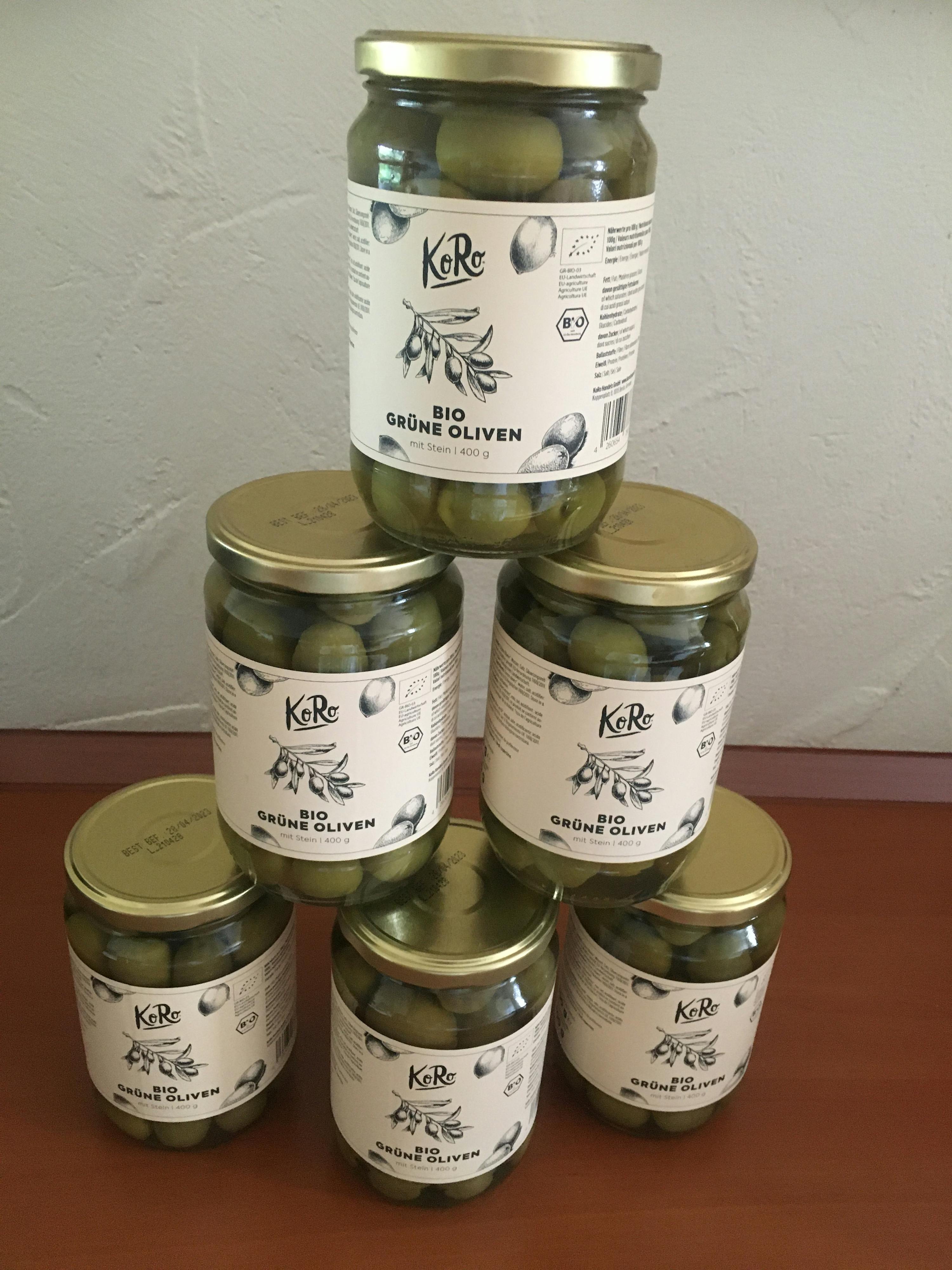several jars of green olives are stacked on top of each other