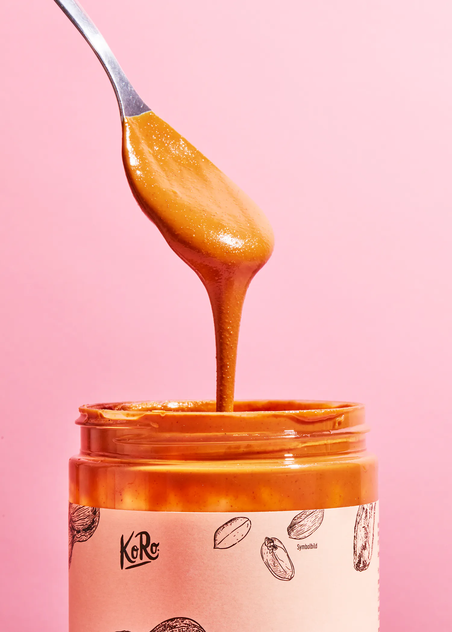 une cuillère de beurre d' arachide est versée d' un bocal de beurre d' arachide