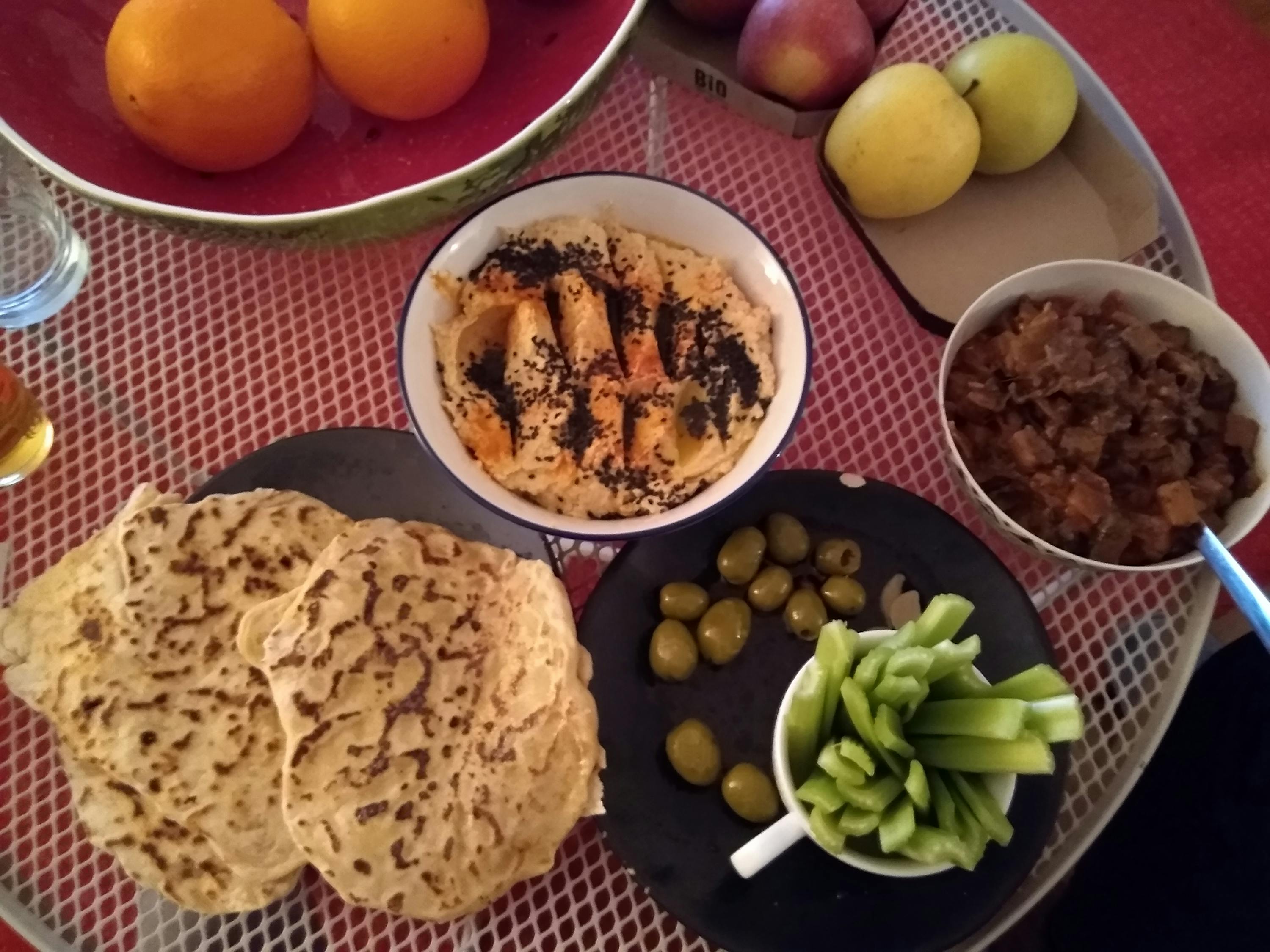 un bol de hummus est assis sur une table à côté d' un bol de pommes