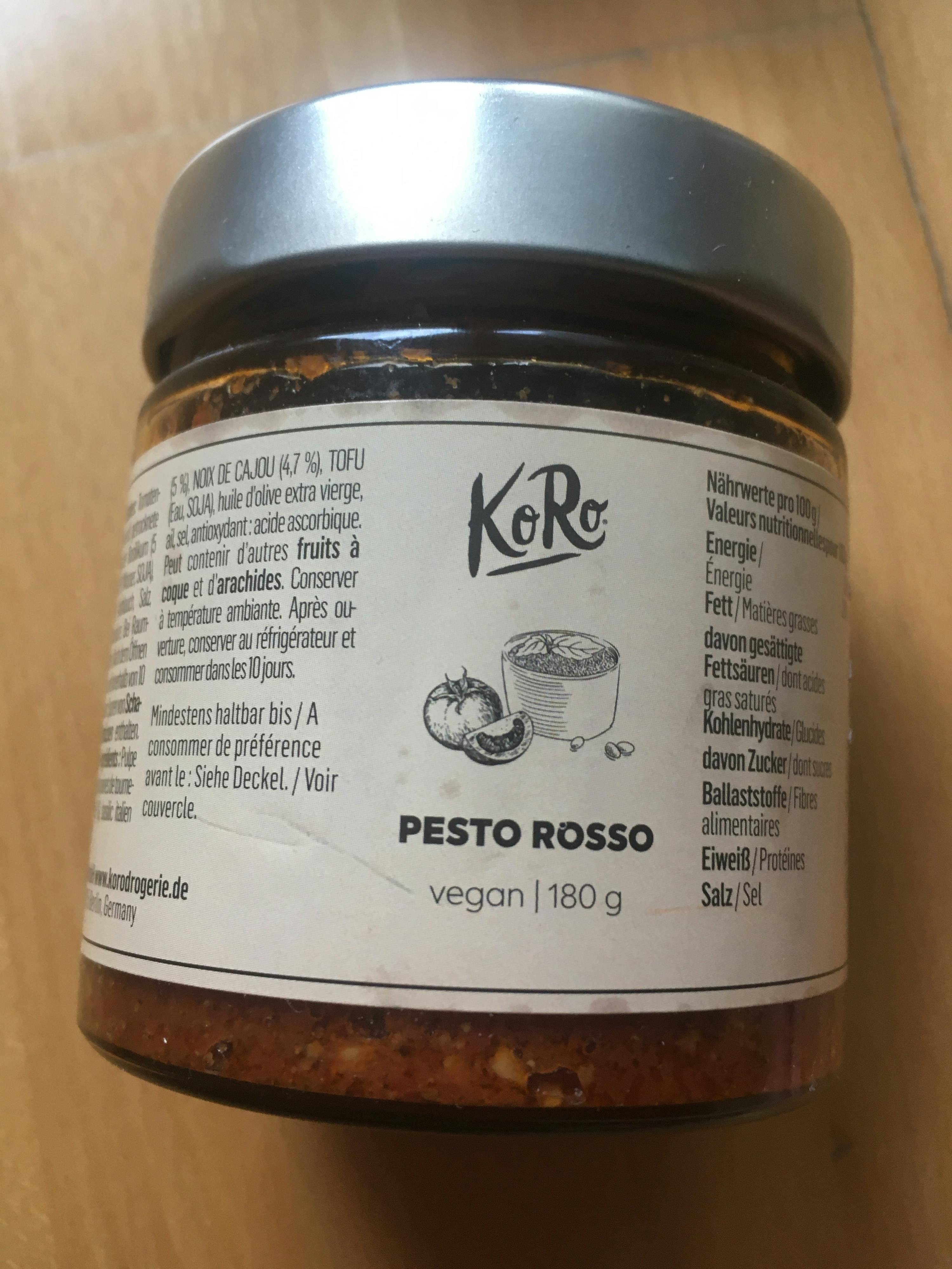 un barattolo di pesto rosso è seduto su un tavolo di legno